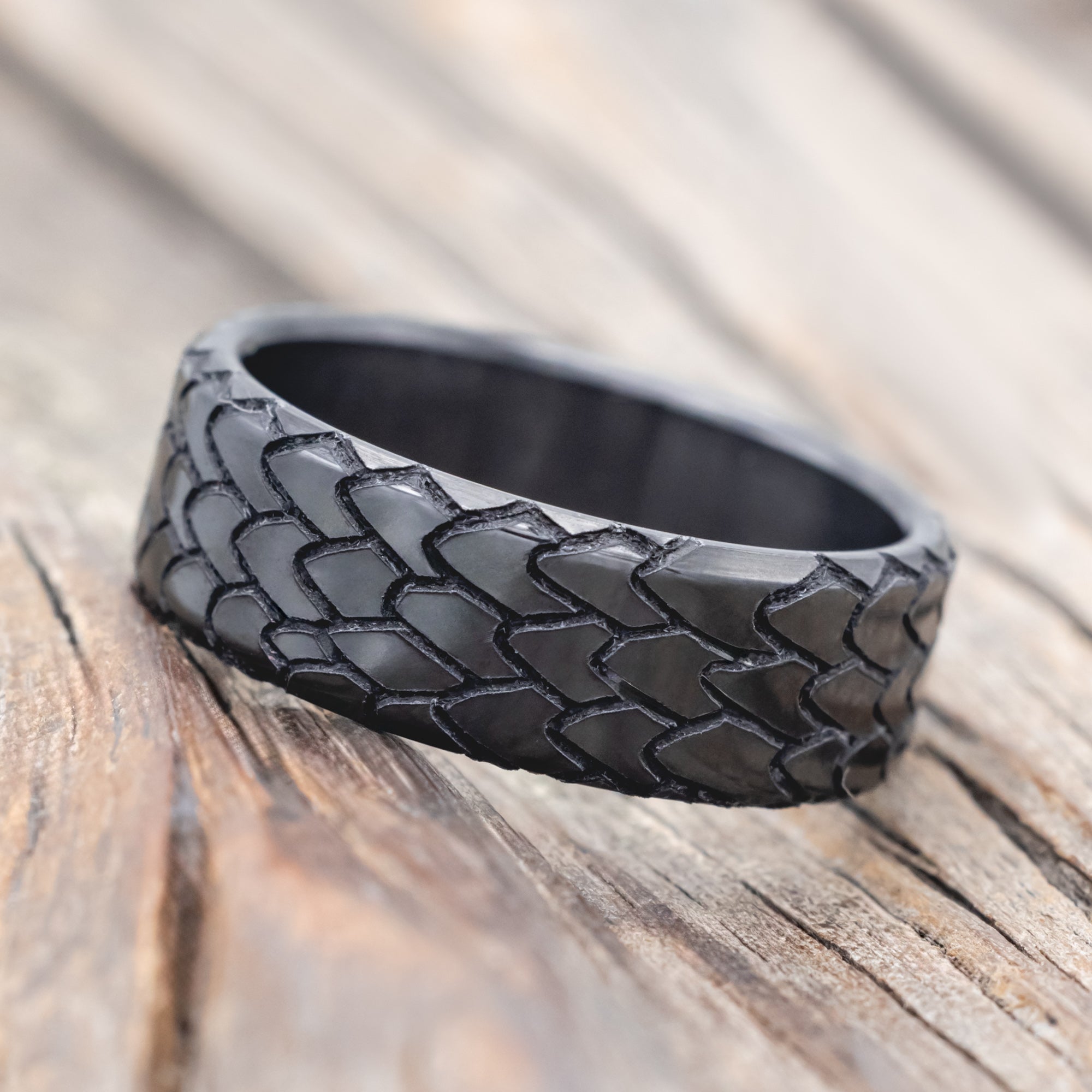 dragon scale engraved wedding band on wooden surface