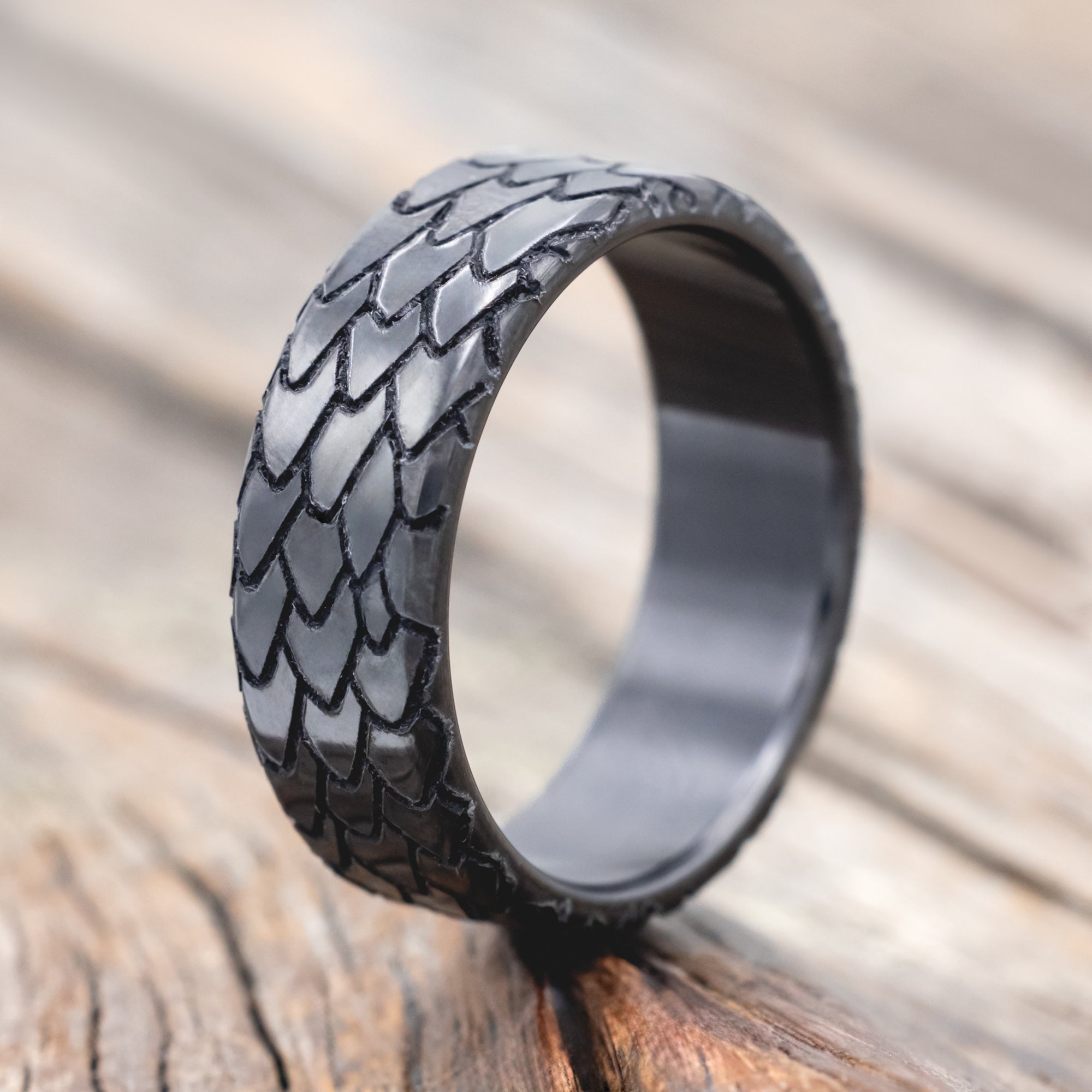 dragon scale engraved wedding band on wooden surface