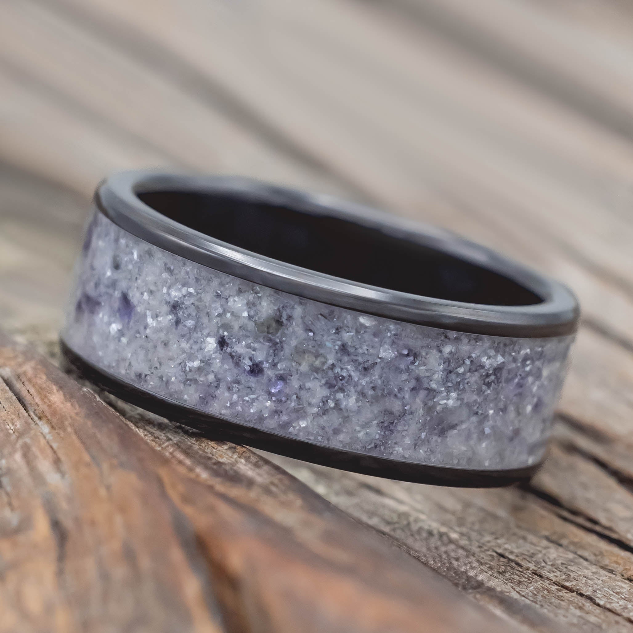 Black and gray ring with a textured design on a wooden surface