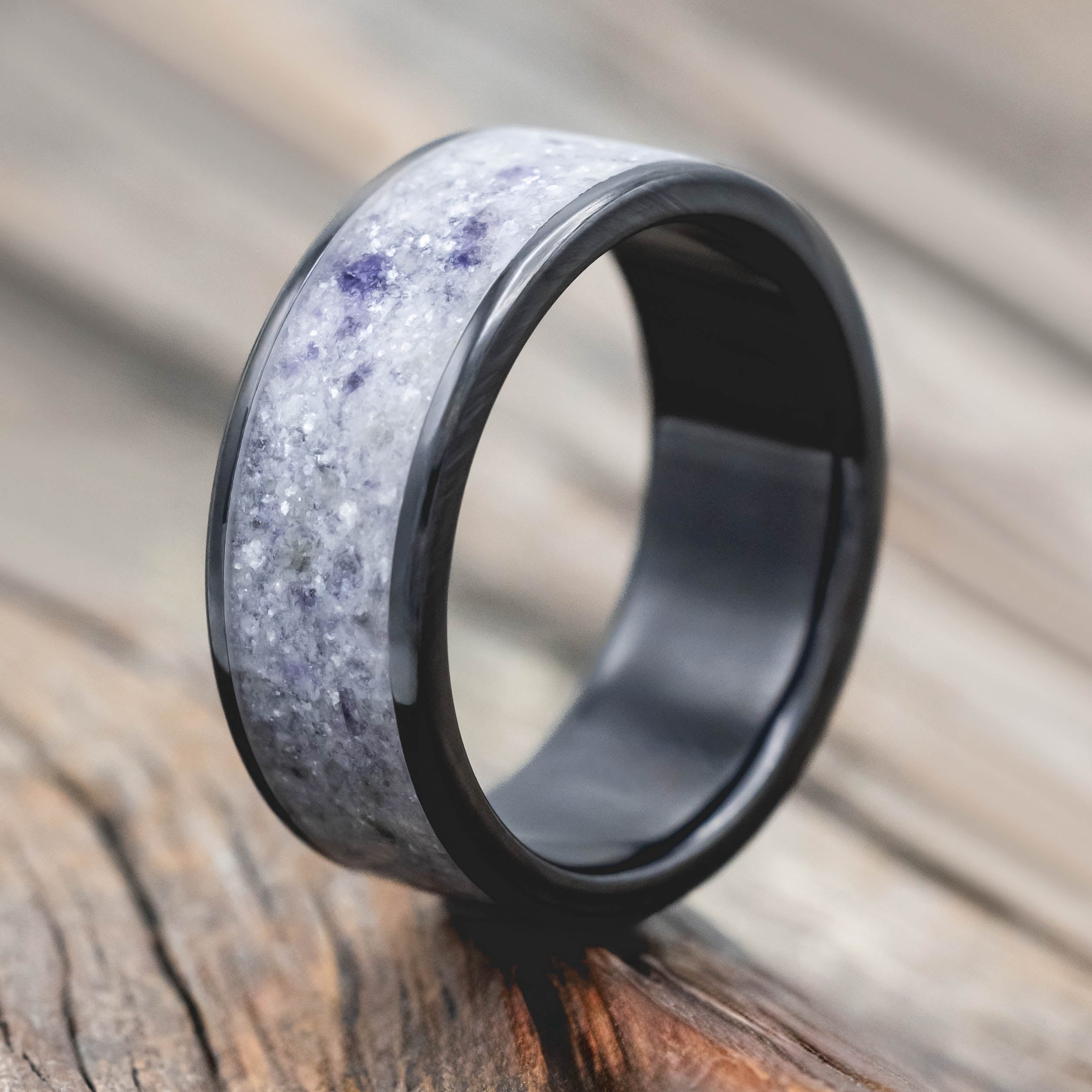 Black and gray ring with a textured design on a wooden surface