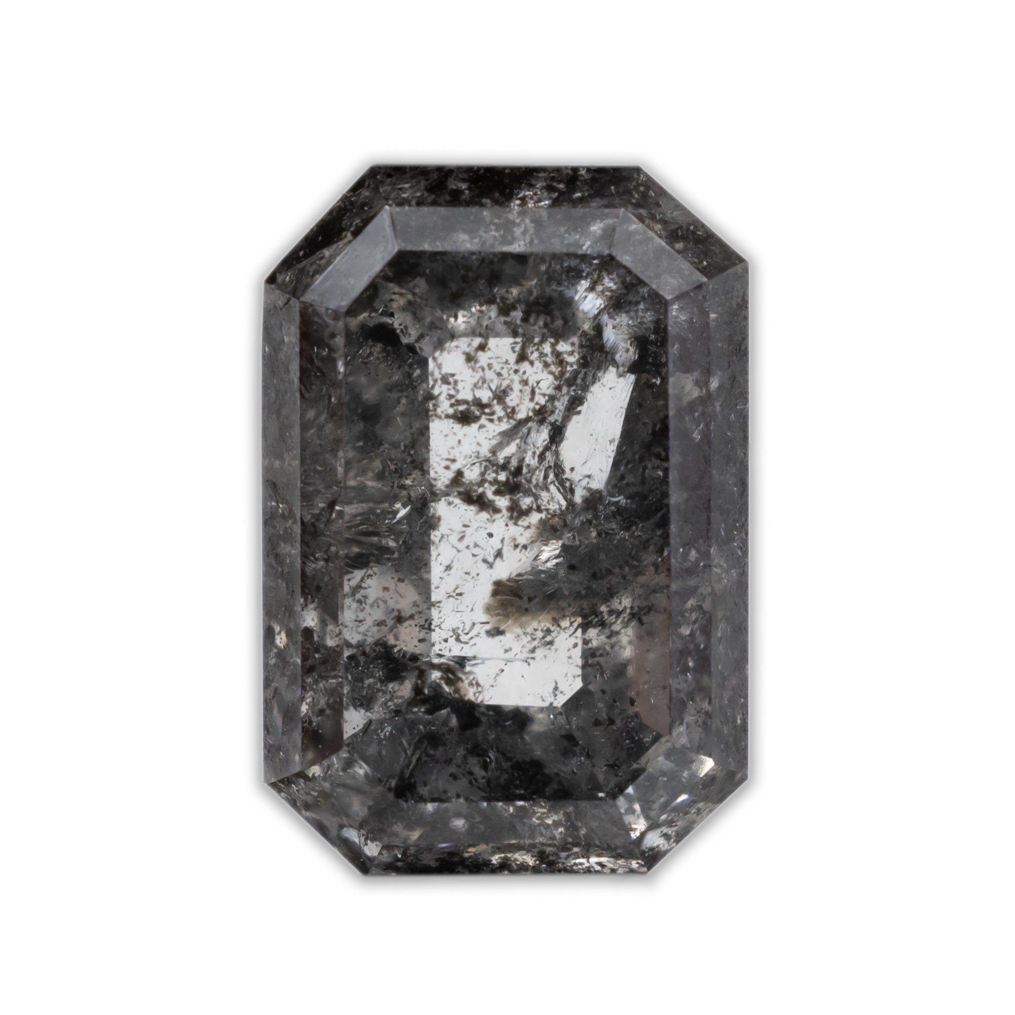 An emerald cut salt & pepper diamond with black inclusions on a white background