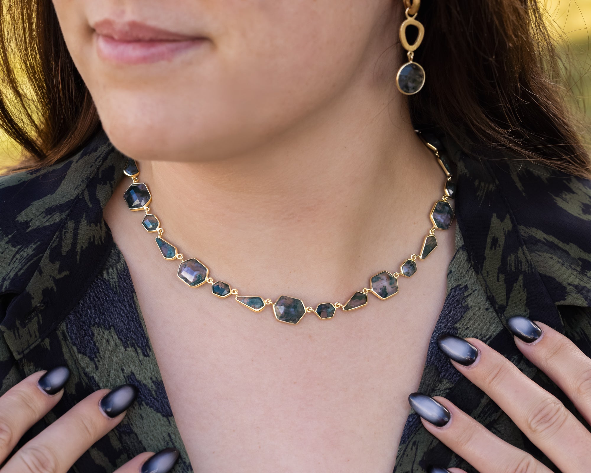 Necklace with gemstones worn by a person, with a blurred background
