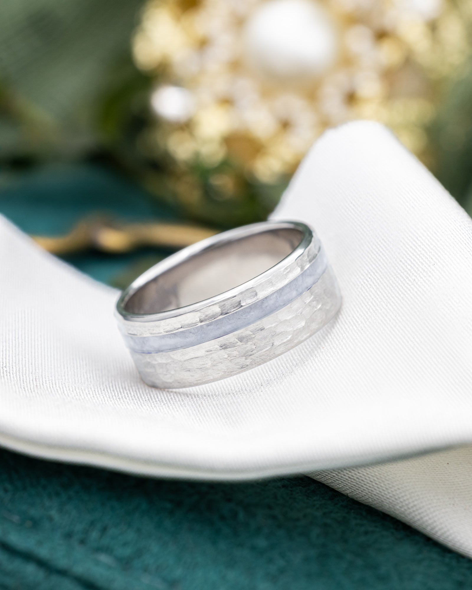 titanium ring with a hammered band on a piece of wedding dress on a piece of white fabric