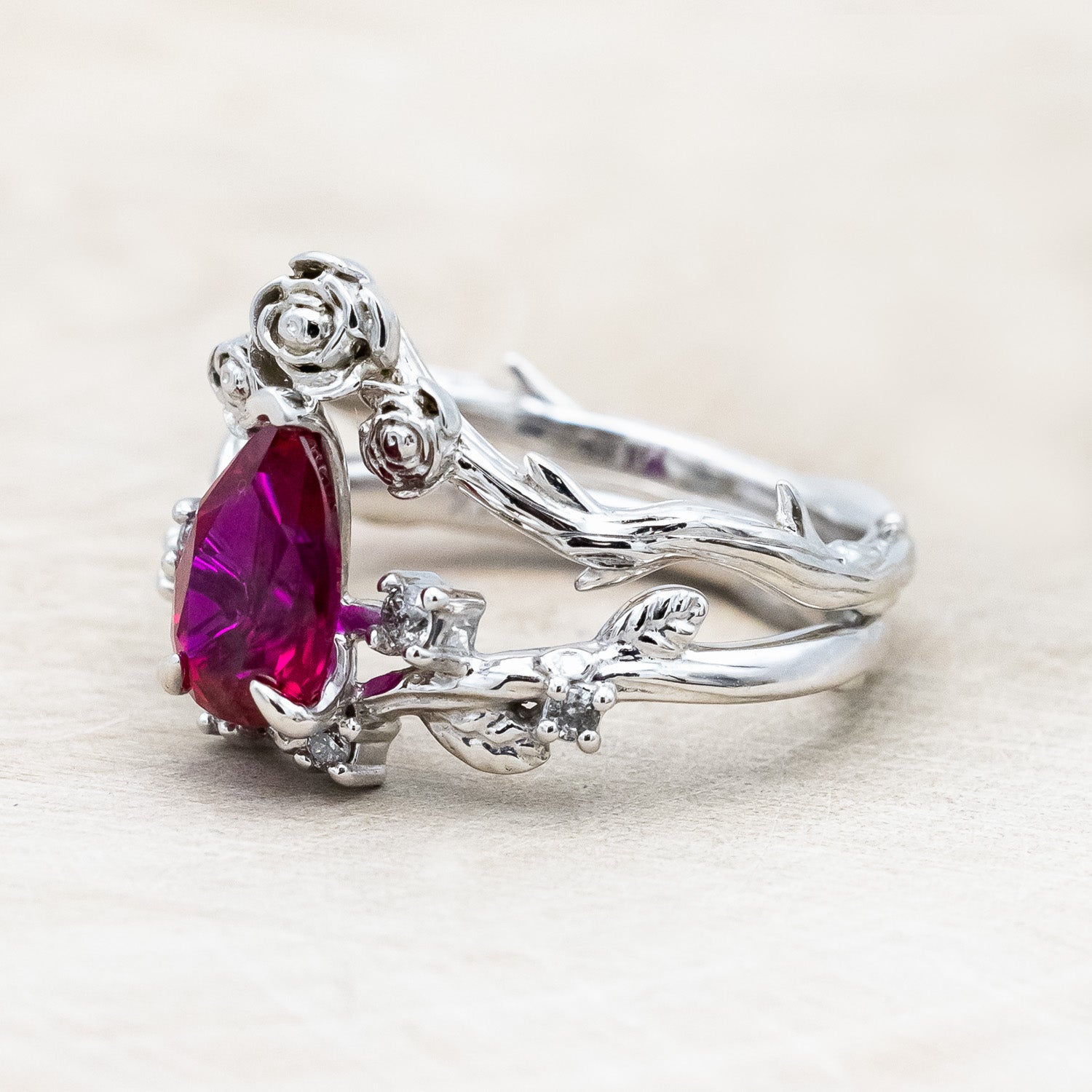 "Harlow" pear cut ruby engagement ring with salt & pepper diamond accents on a branch-inspired band and floral style tracer