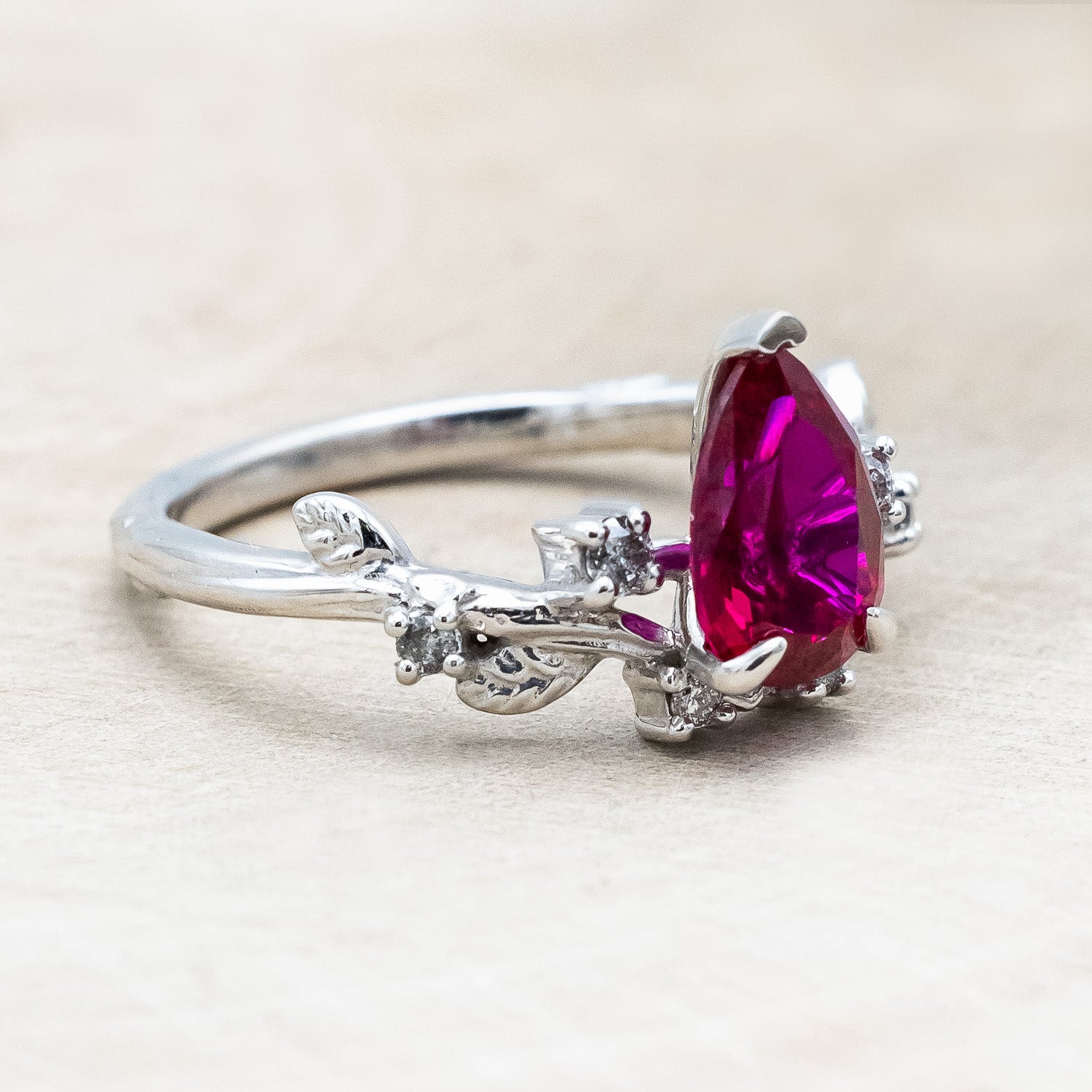 "Harlow" pear cut ruby engagement ring with salt & pepper diamond accents on a branch-inspired band
