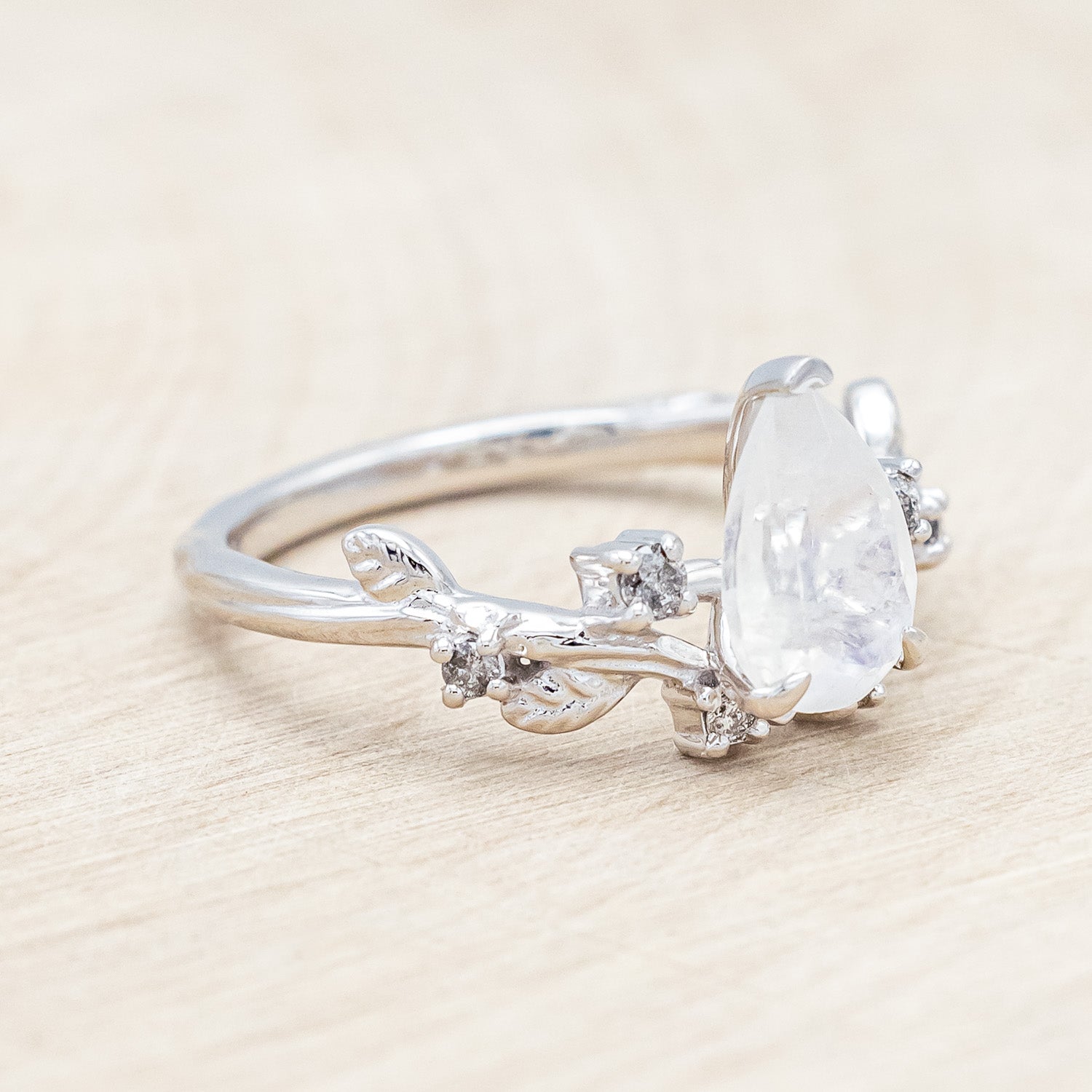 Side view of "Harlow" - moonstone women's engagement ring with salt & pepper diamond accents on a branch-inspired band