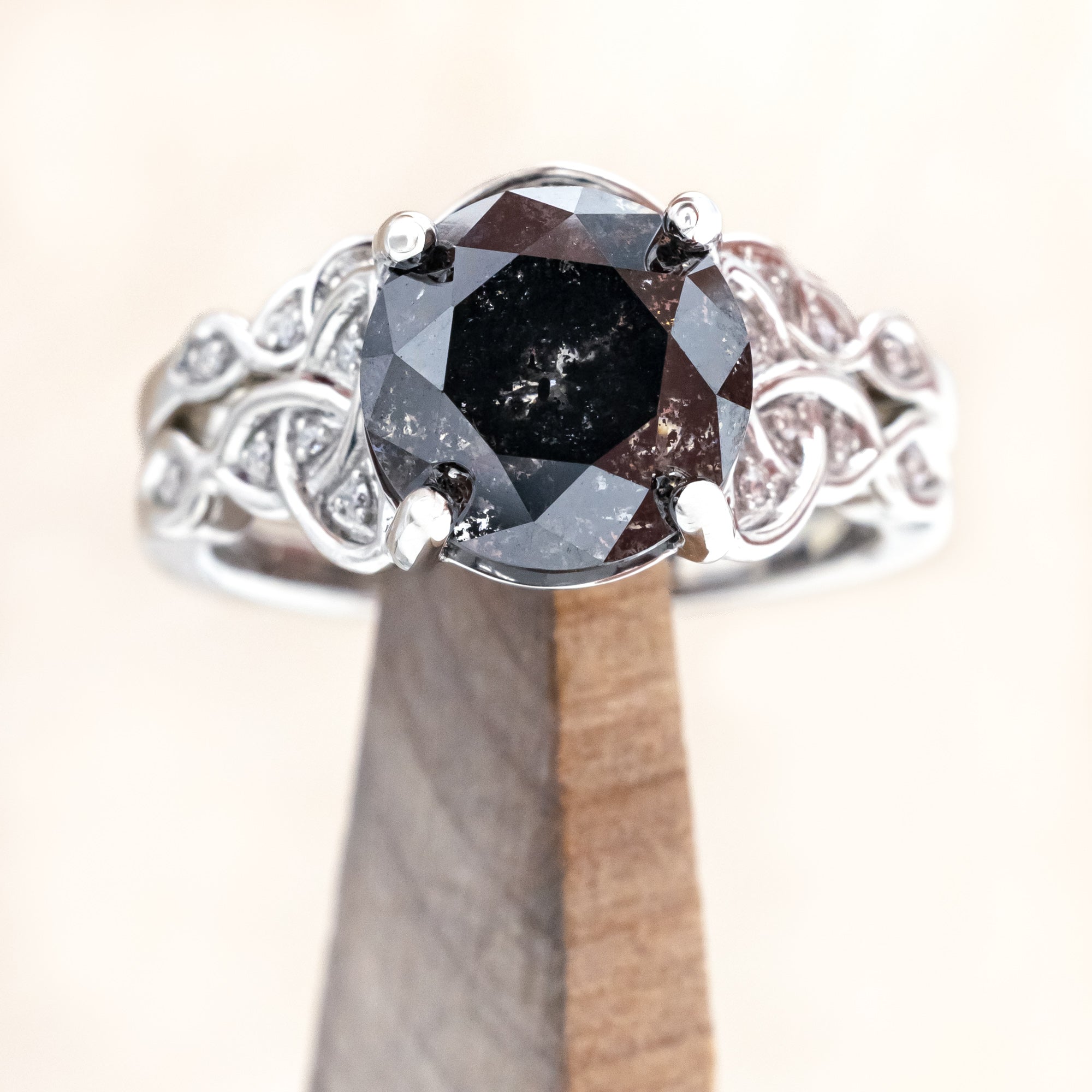 14K white gold ring with a salt & pepper diamond on a wooden stand
