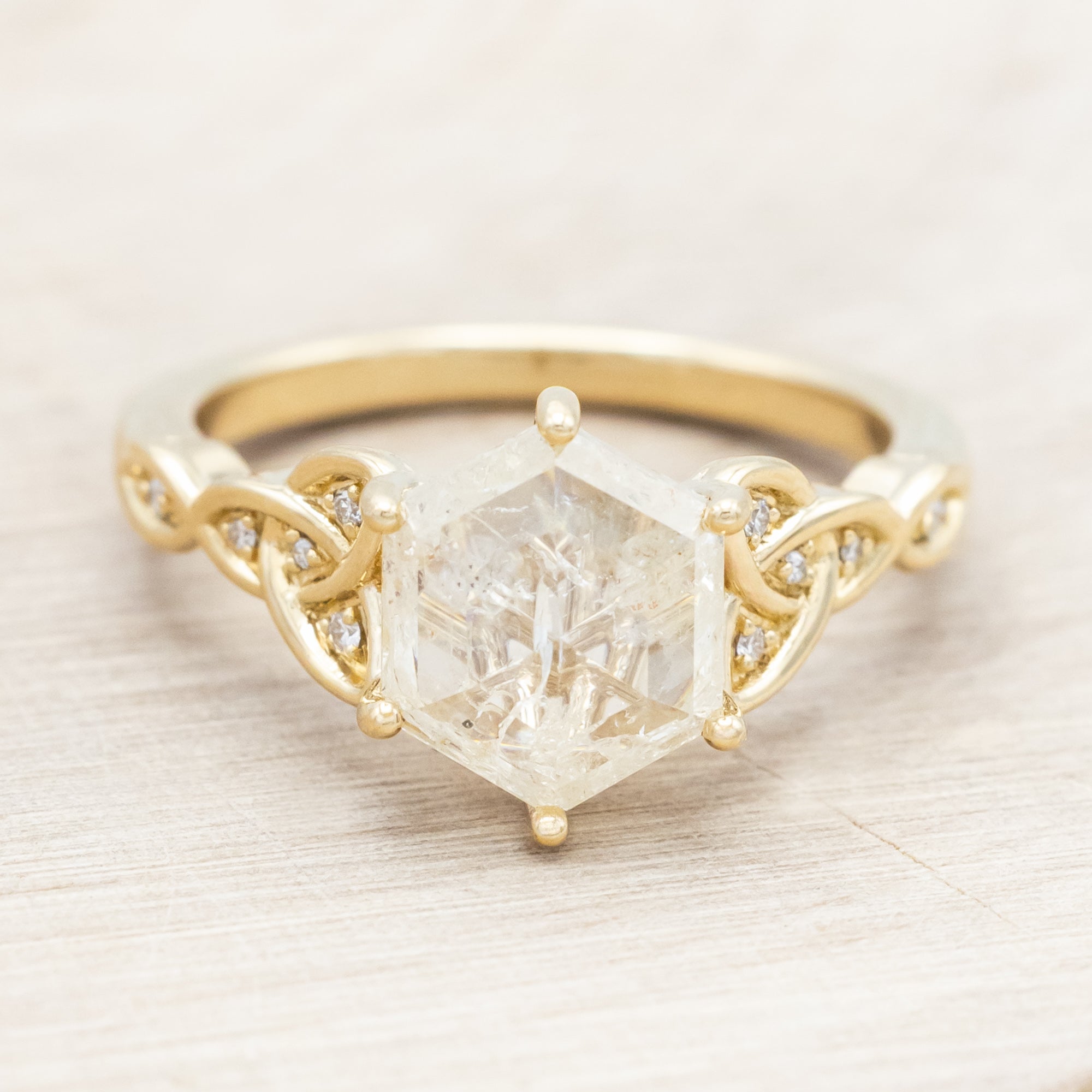 14K gold ring with an icy salt & pepper diamond on a beige background