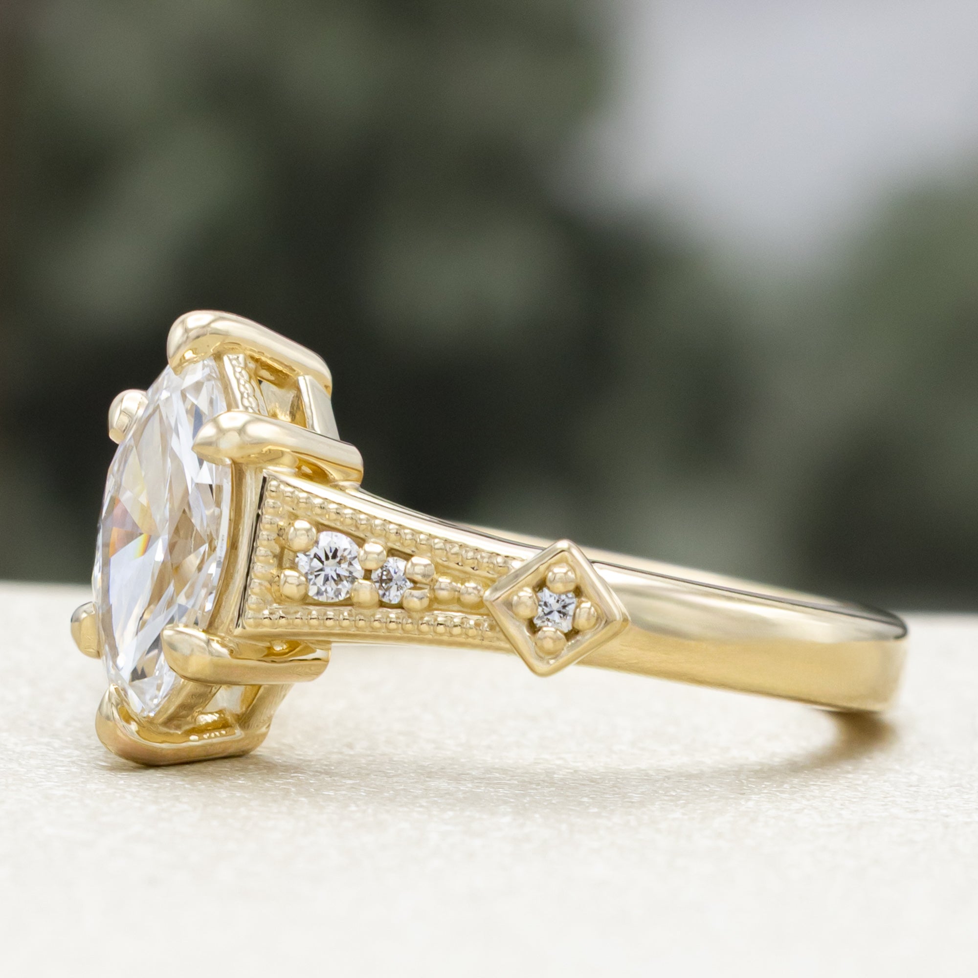 Gold lab diamond ring with diamond accents on a blurred background