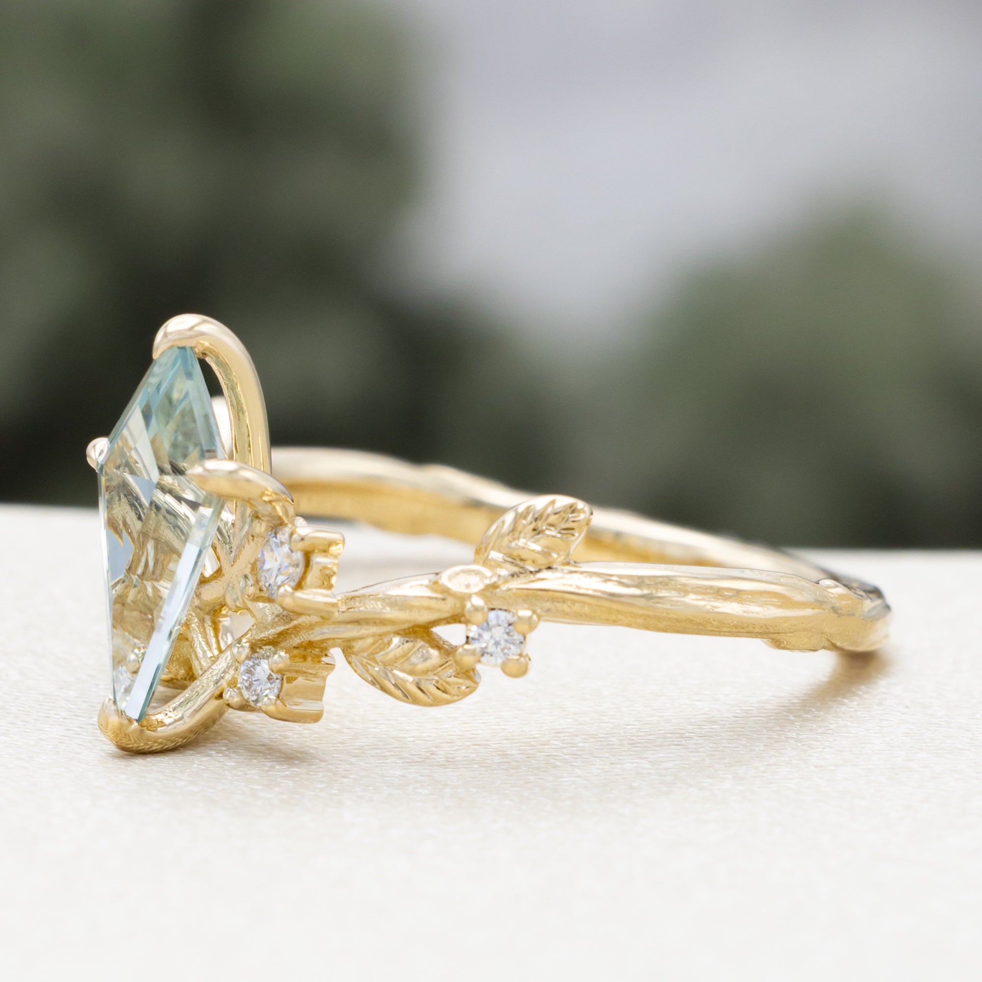 Gold ring with moss agate and diamond accents on a white surface.