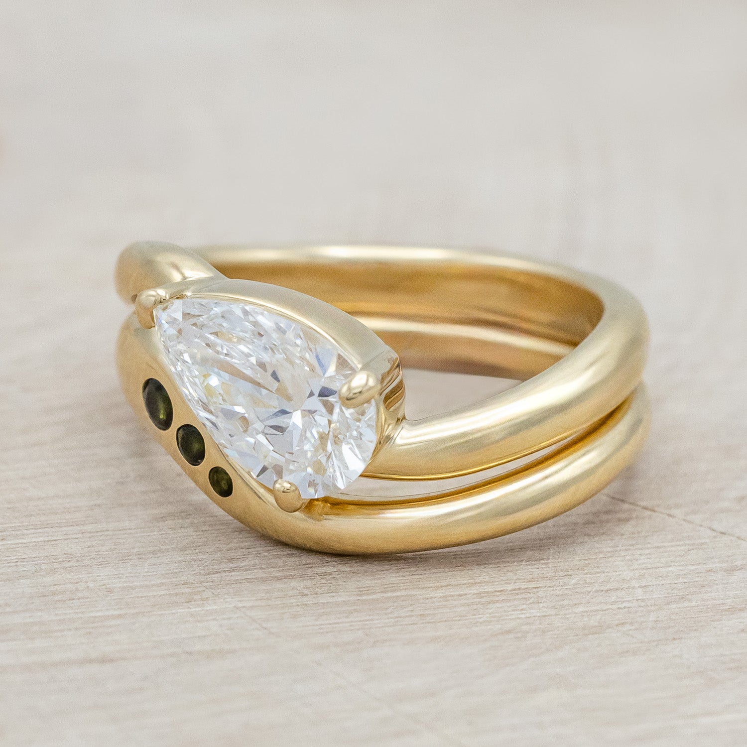 Side view of "Sybil" - asymmetrical solitaire-style lab diamond women's engagement ring with green tourmaline tracer