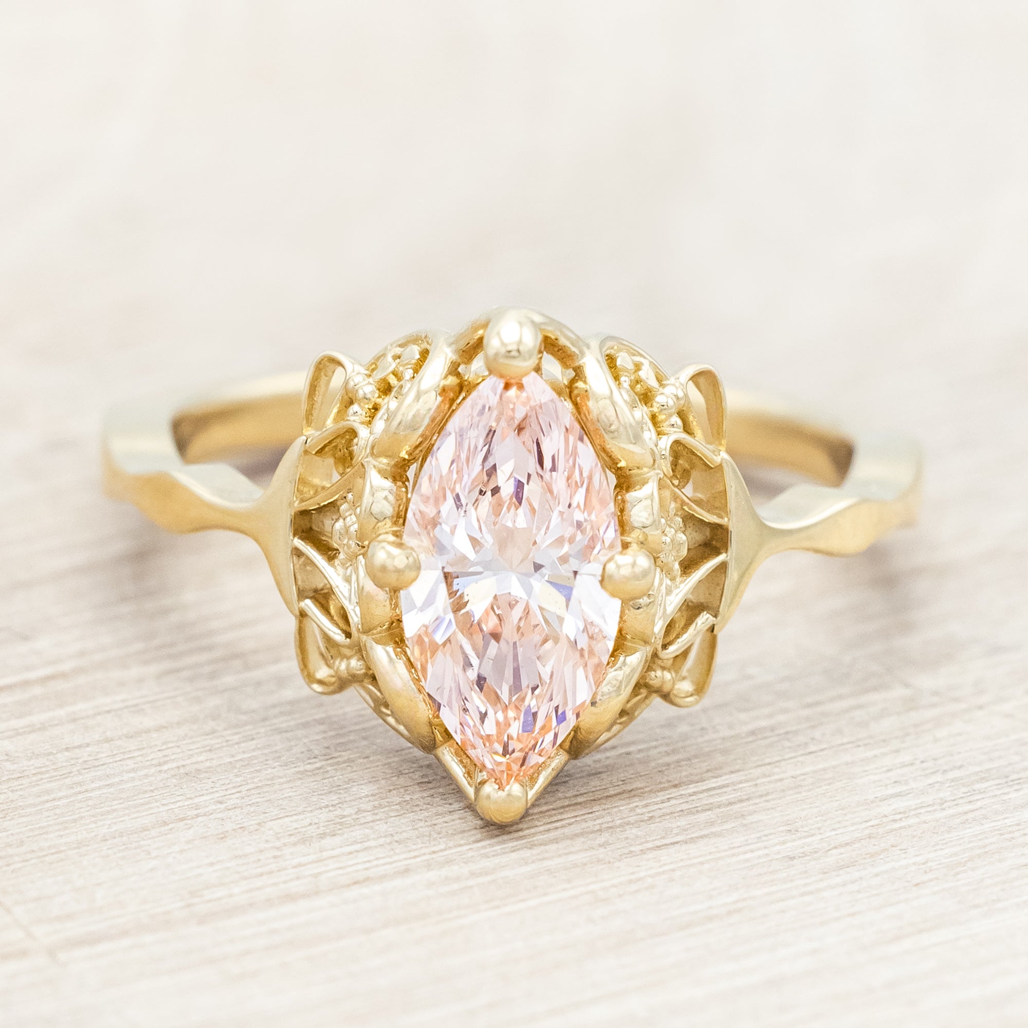 14K yellow gold ring with a pink lab diamond on a neutral background