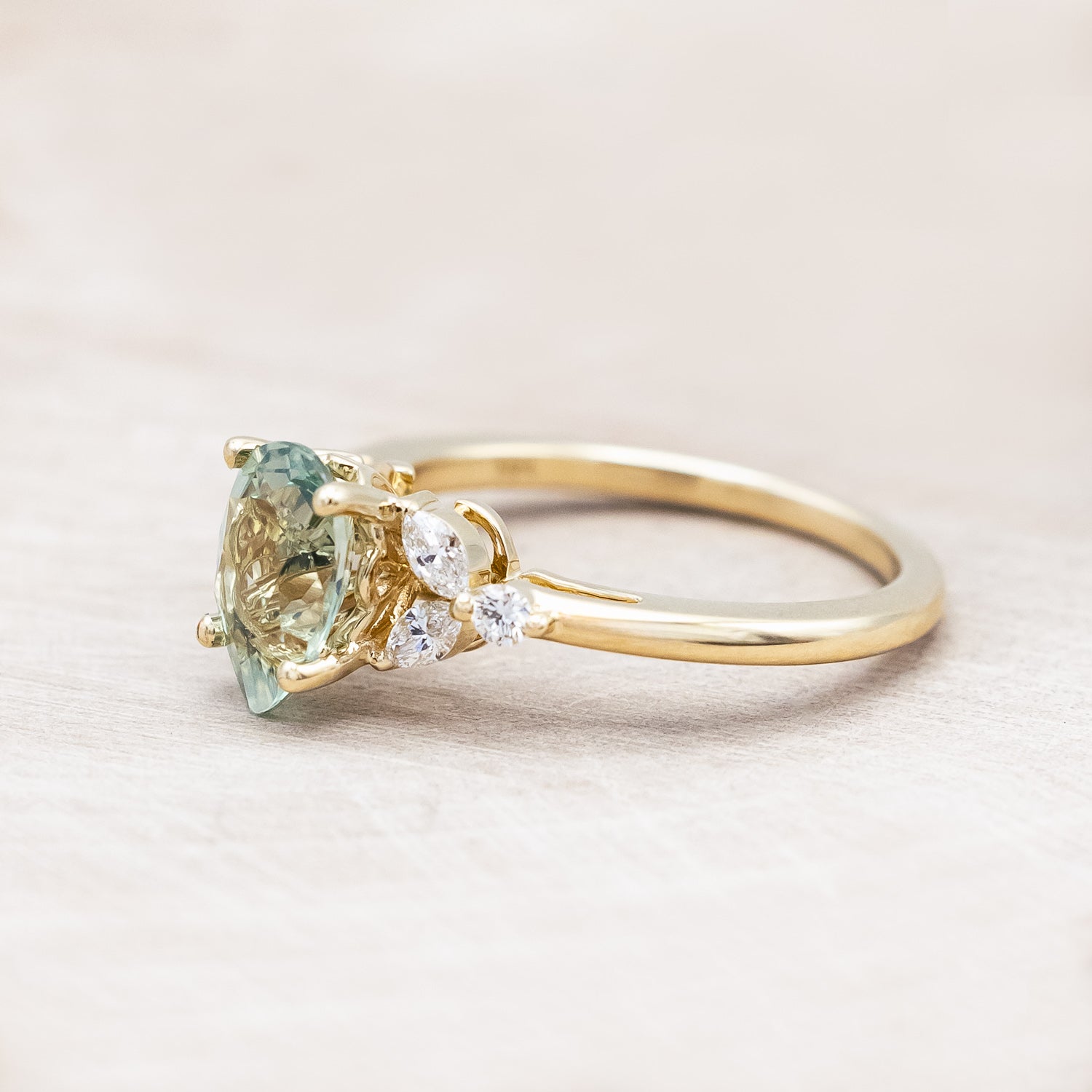 Side view of "Blossom" - pear cut lab-grown green sapphire women's engagement ring with diamond accents