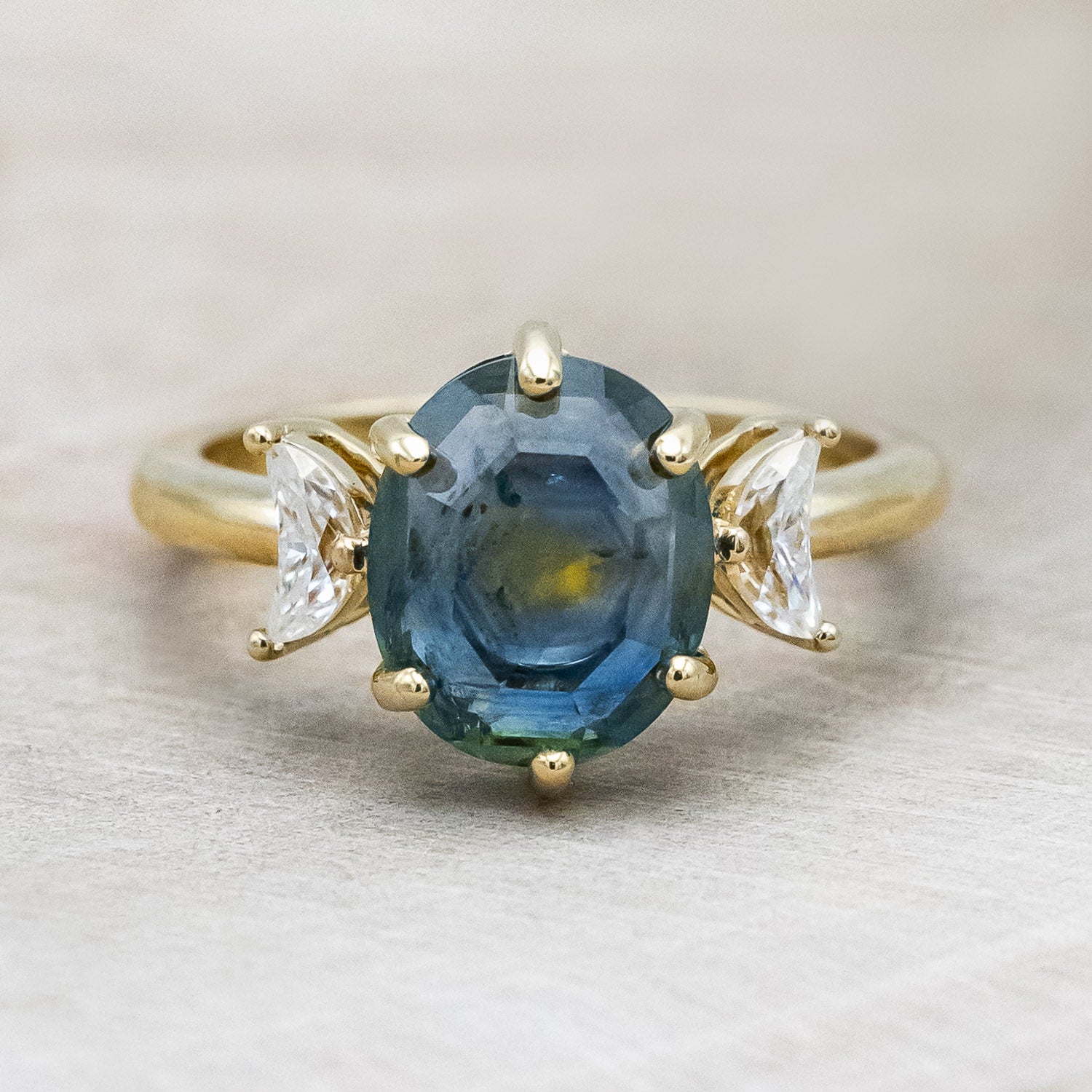 "Rhiannon" engagement ring with a portrait cut Montana sapphire and two crescent moon moissanite accents