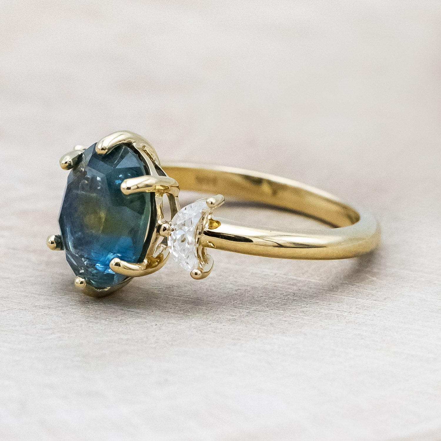 "Rhiannon" engagement ring with a portrait cut Montana sapphire and two crescent moon moissanite accents