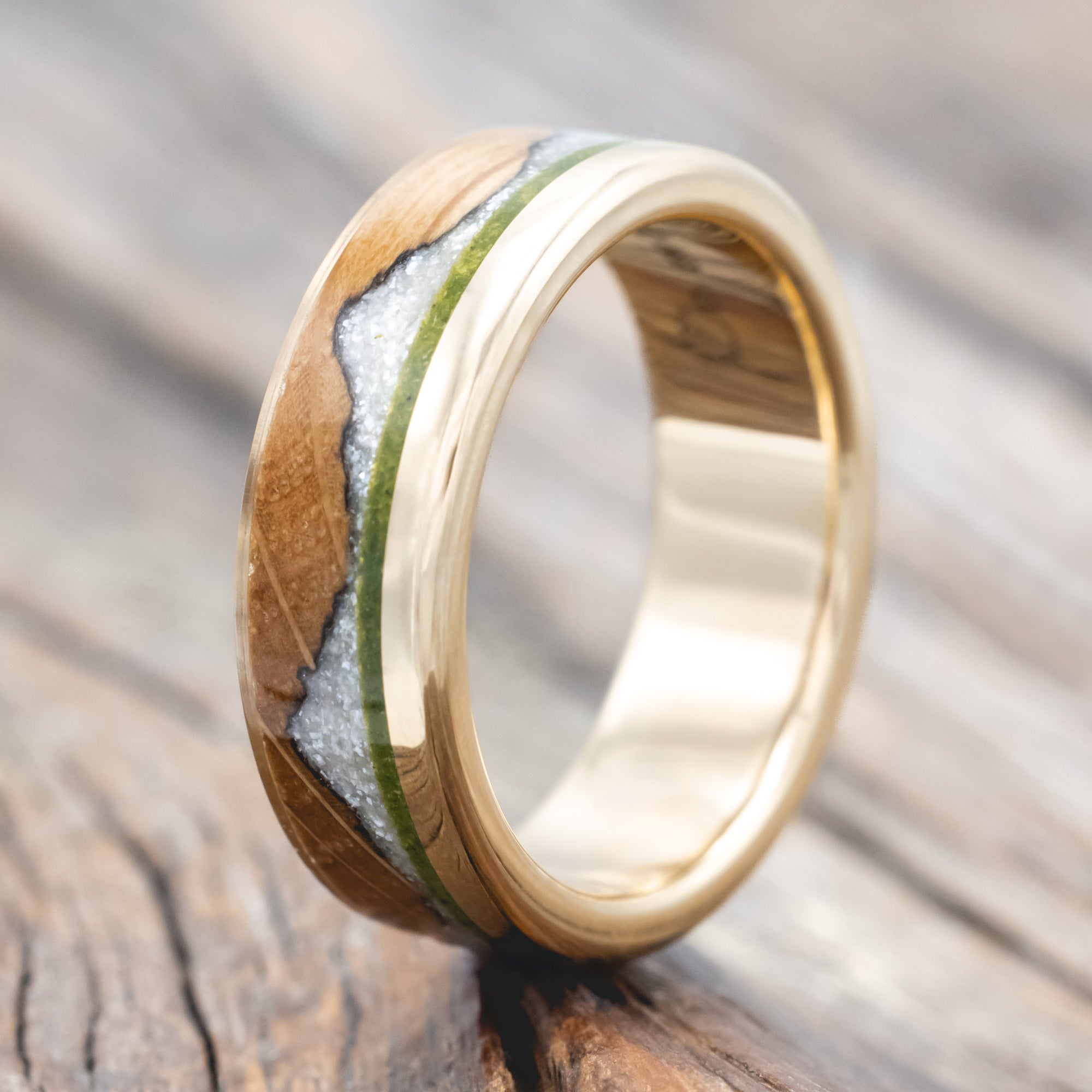 whiskey barrel oak ring with moss and diamond dust inlay on a wooden surface