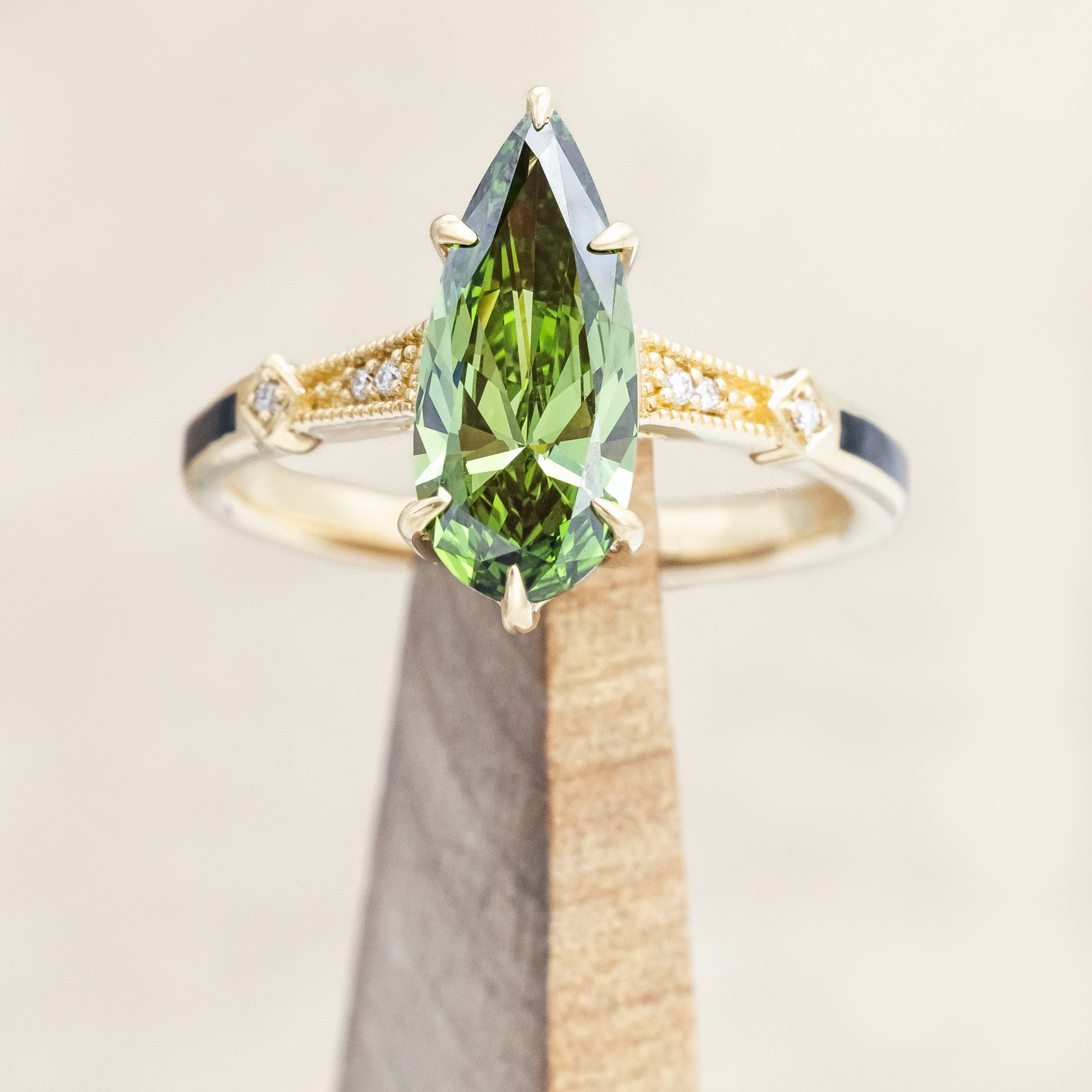 14K yellow gold ring with a green diamond on a neutral background