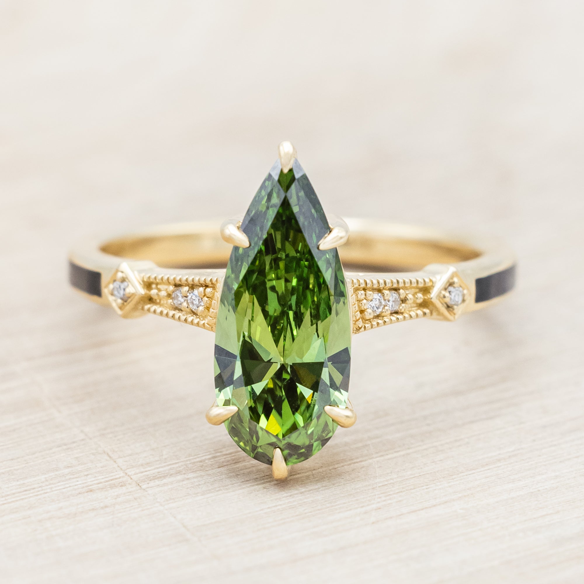 14K yellow gold ring with a green diamond on a neutral background