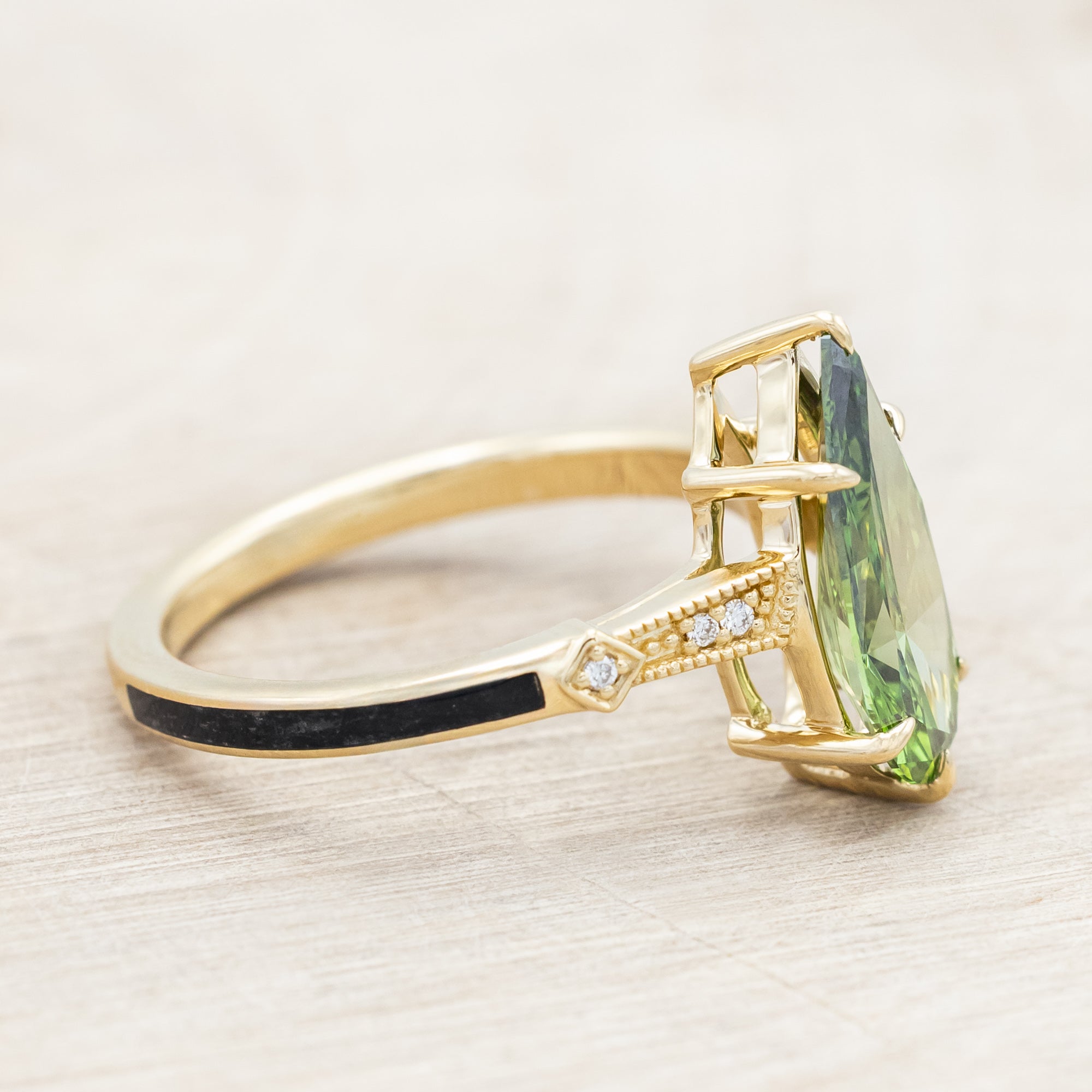 14K yellow gold ring with a green diamond on a neutral background