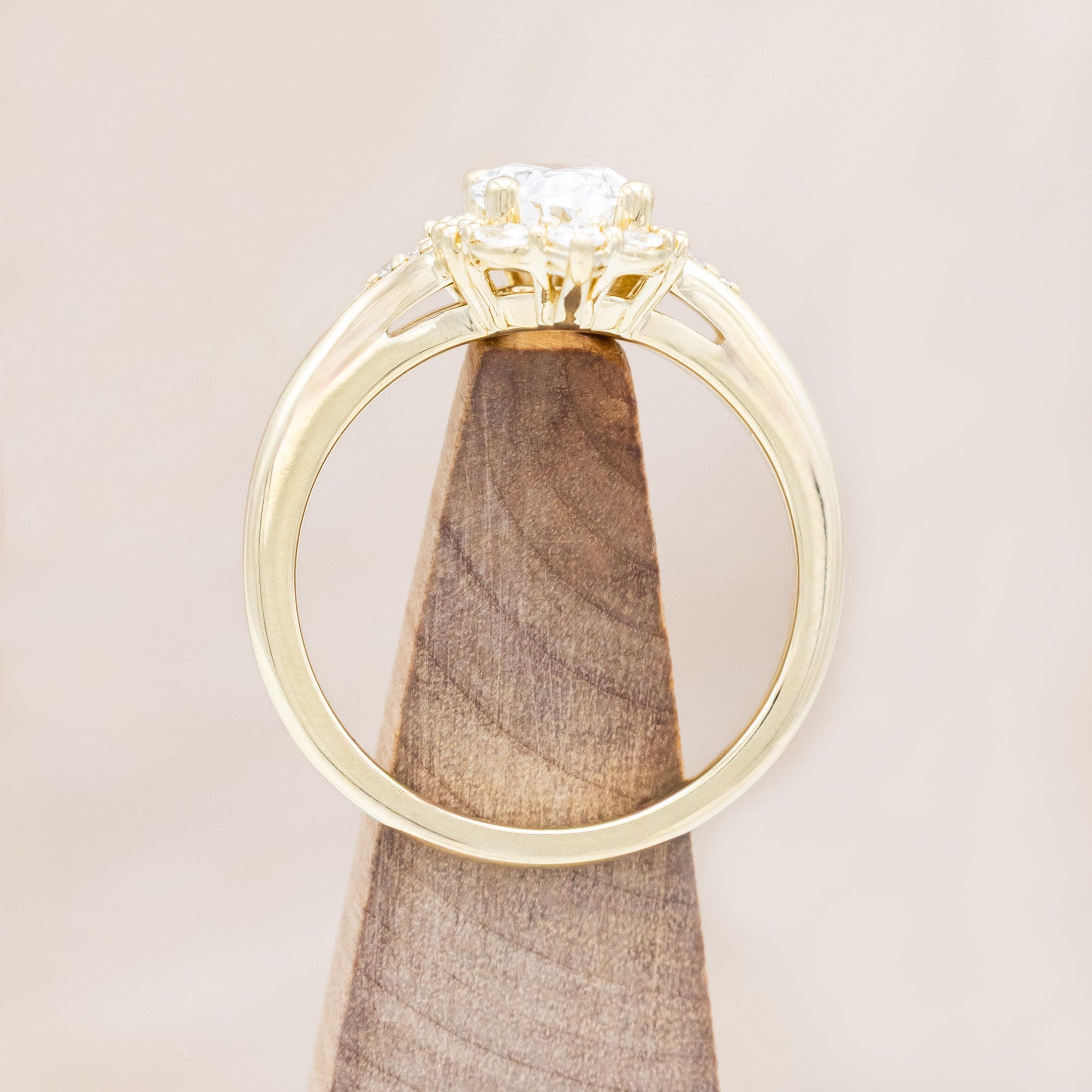 14K gold ring with an oval lab diamond on a beige background