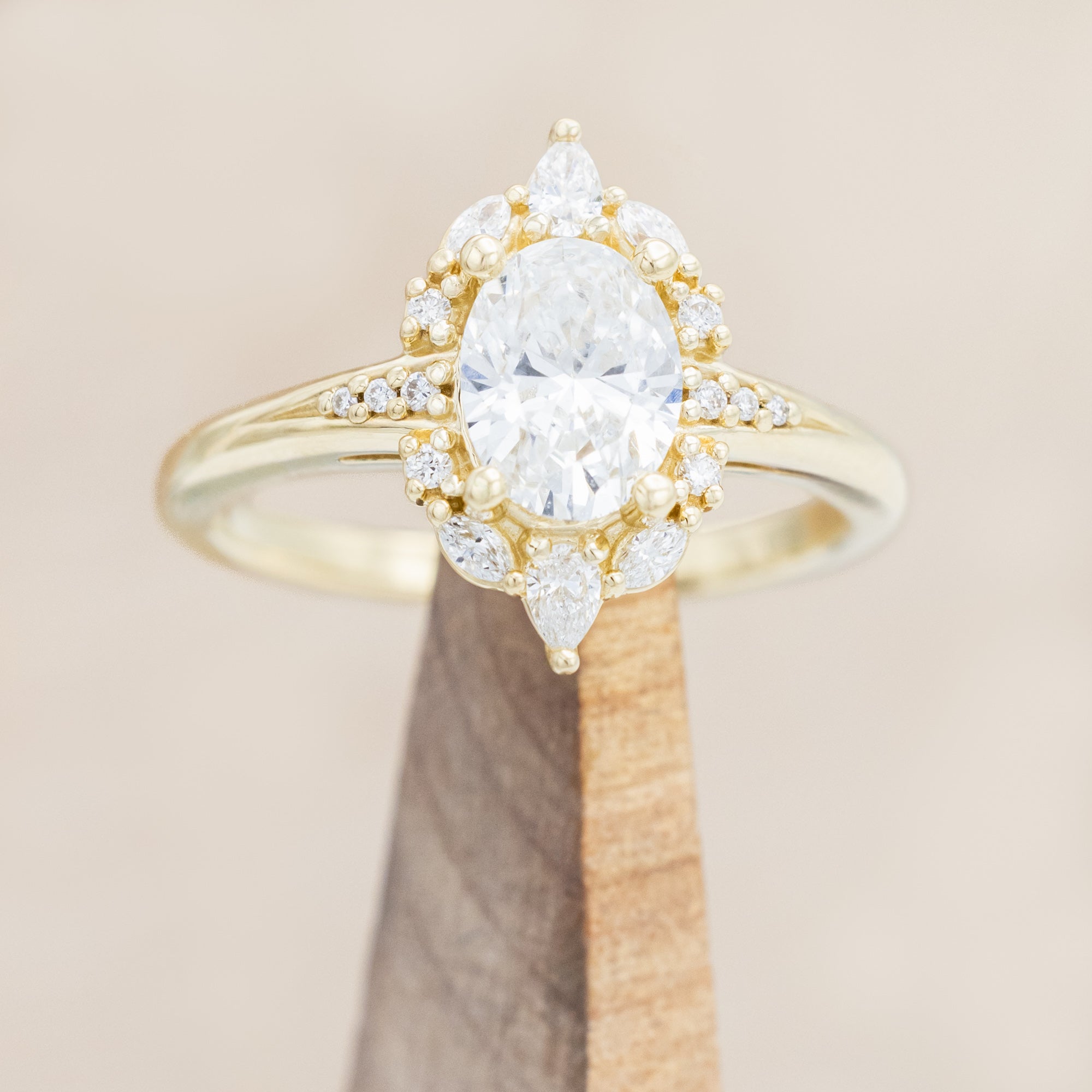 14K gold ring with an oval lab diamond on a beige background
