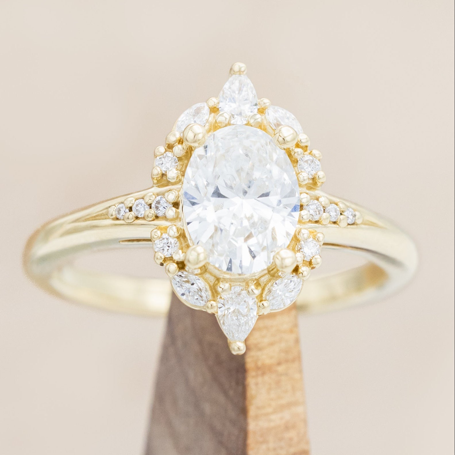14K gold ring with an oval lab diamond on a beige background