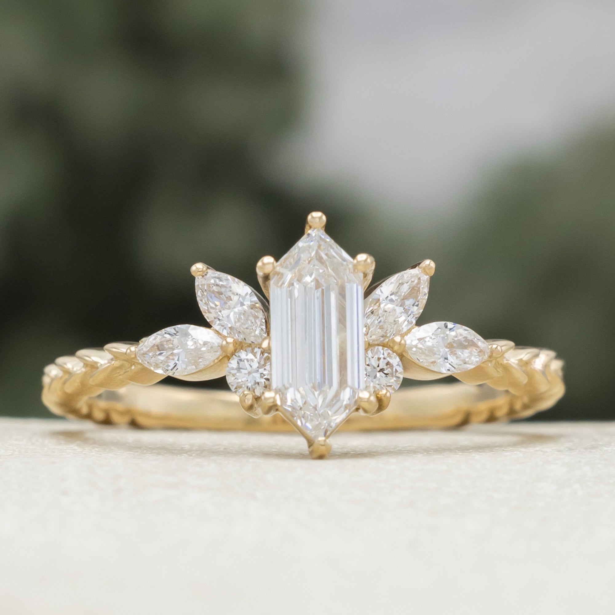 Gold ring with diamond centerstone and accents on a neutral background