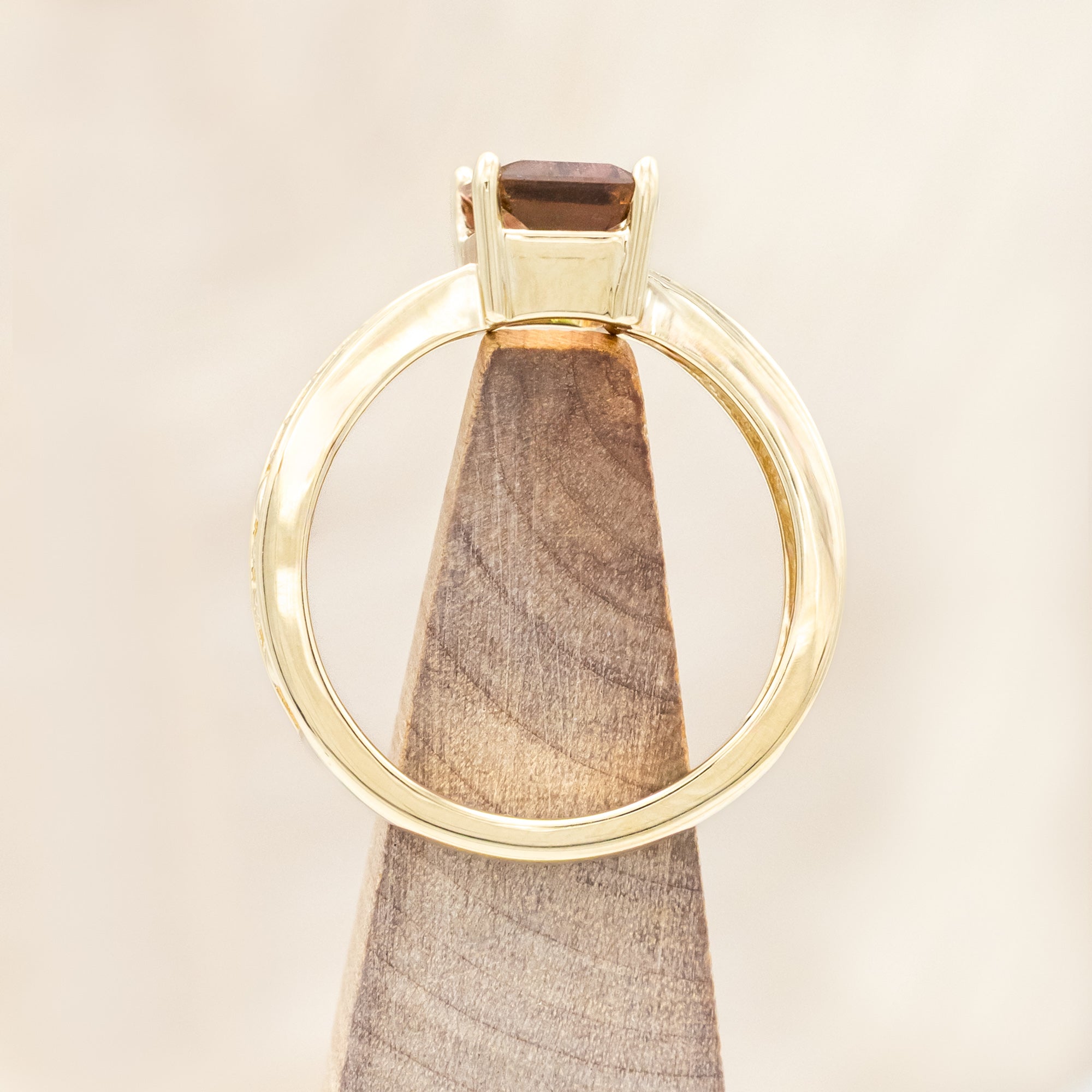 14K gold ring with a green and pink gemstone on a beige background