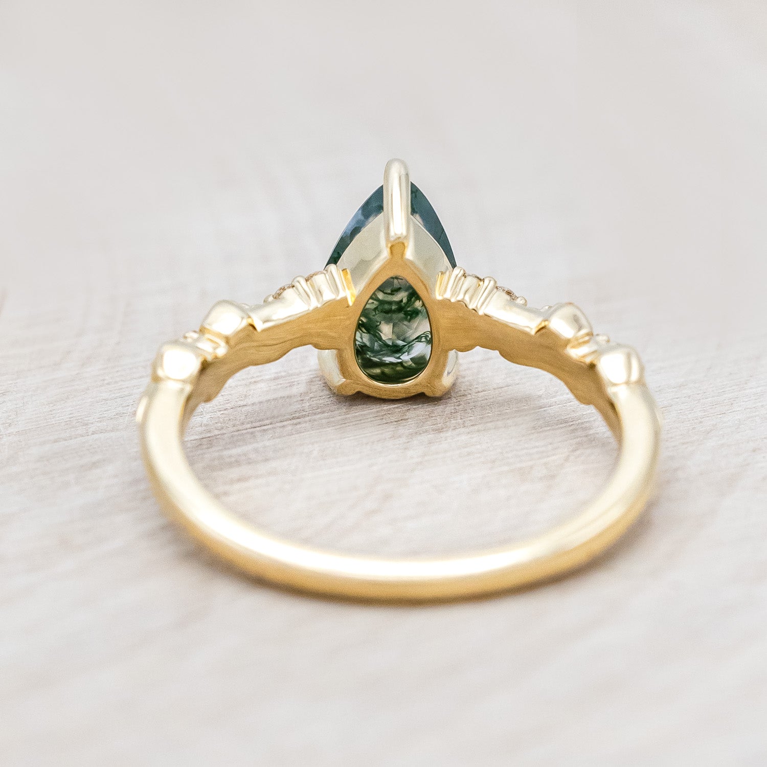 Back view of "Lynette" - pear cut moss agate women's engagement ring with diamond accents on leaf band