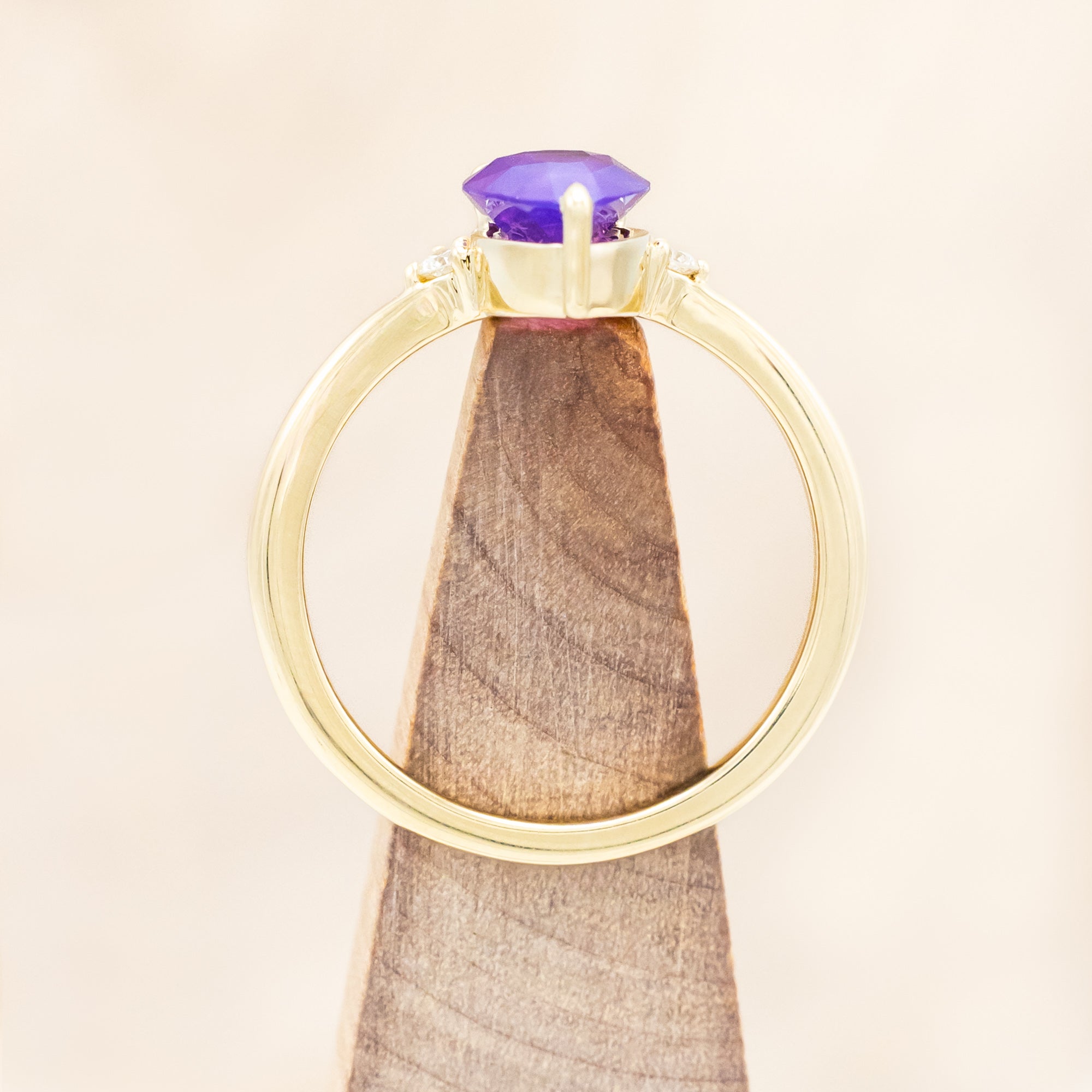 14K gold ring with a pear Sri Lankan sapphire on a beige background