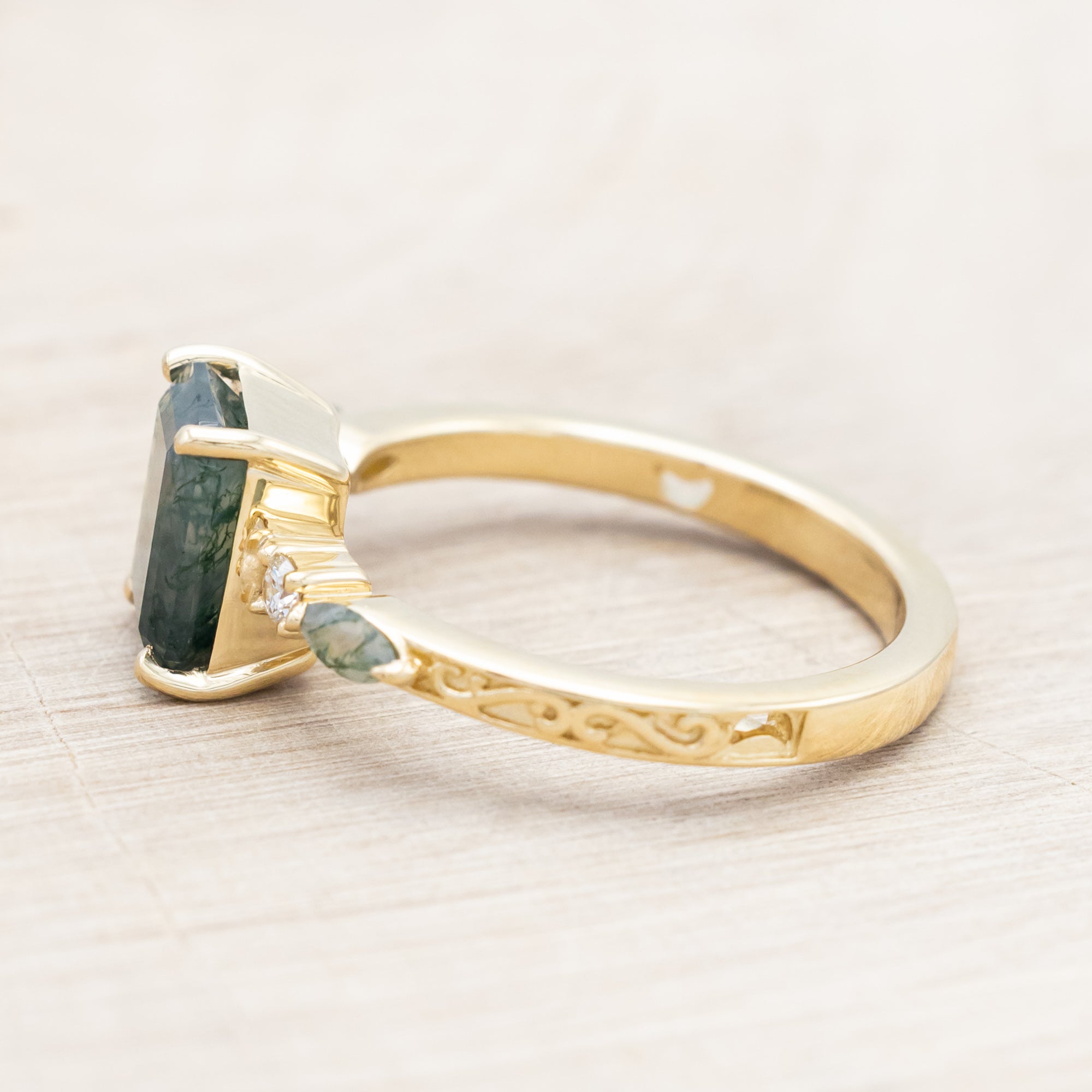 14K gold ring with a moss agate and diamonds on a beige background