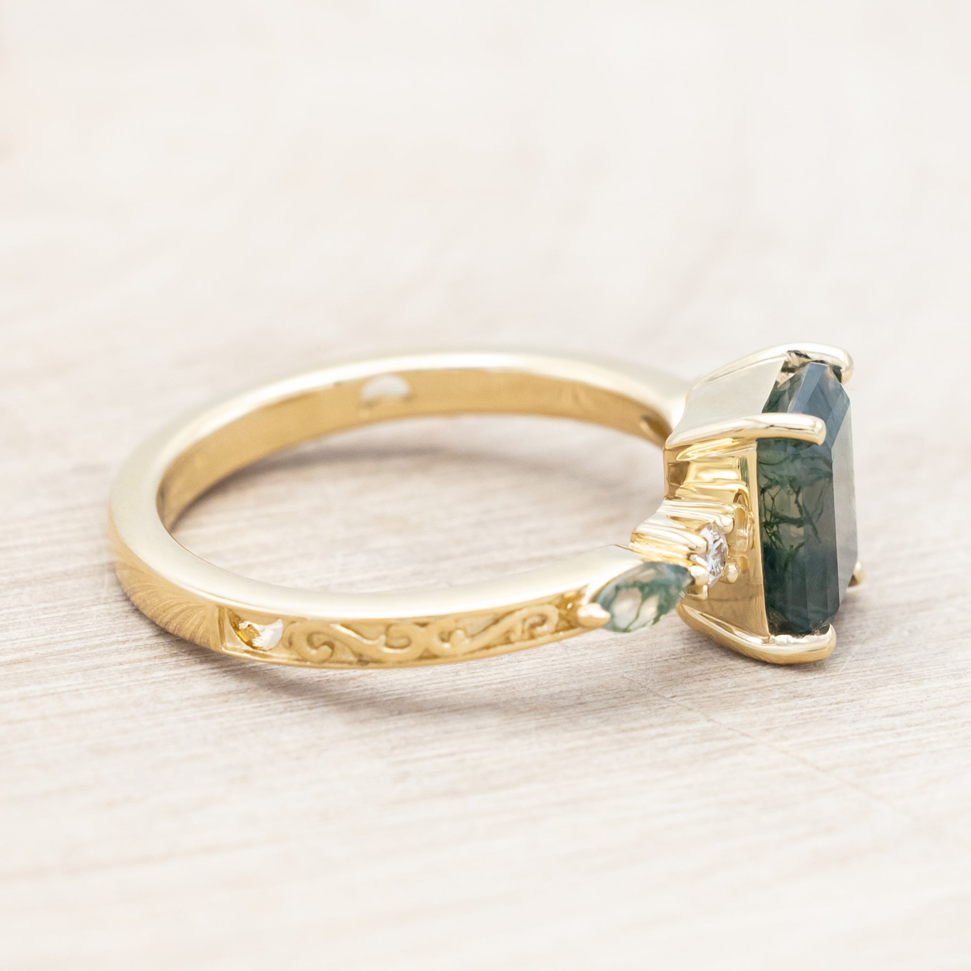 14K gold ring with a moss agate and diamonds on a beige background