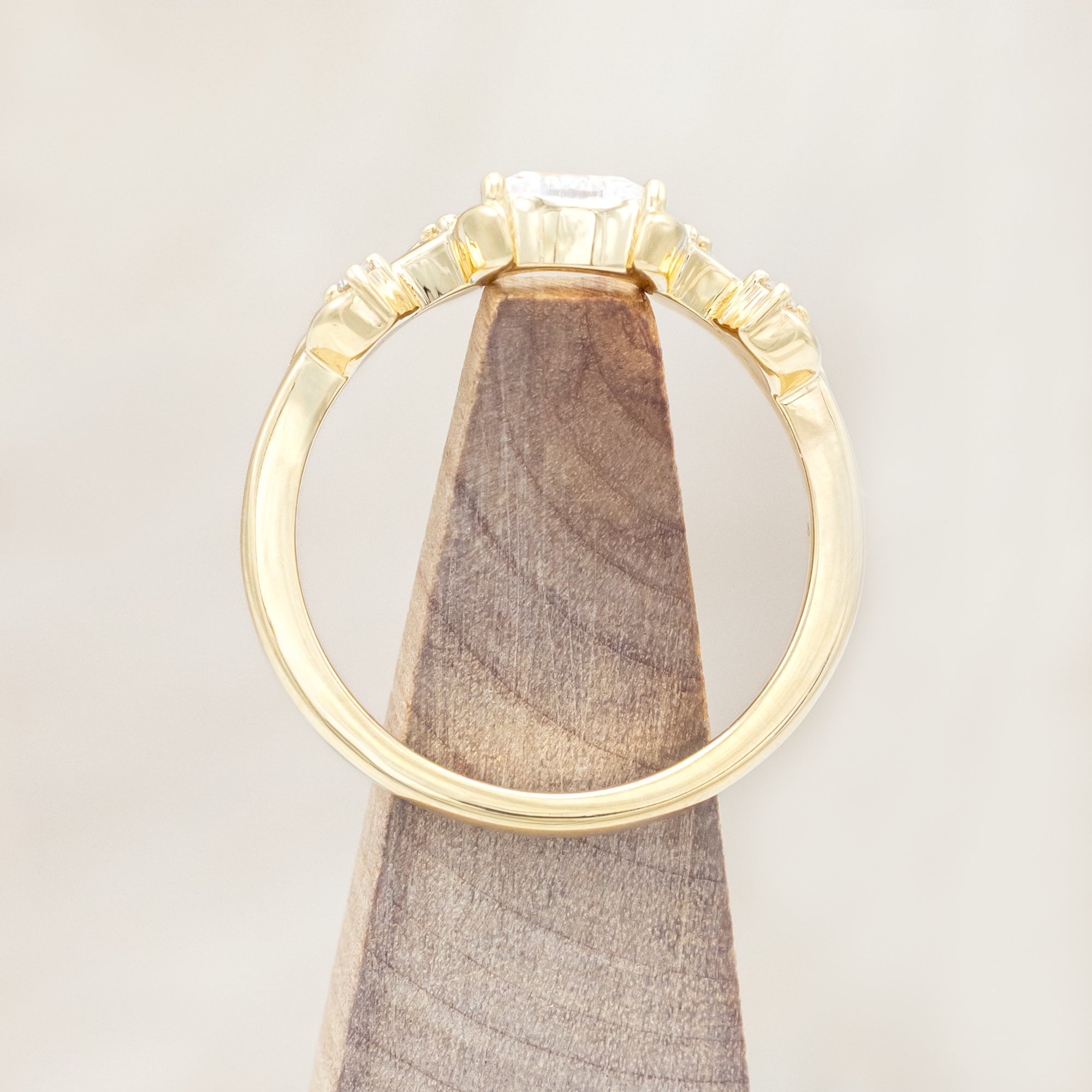 14K gold ring with diamond & moissanite accents on a beige background