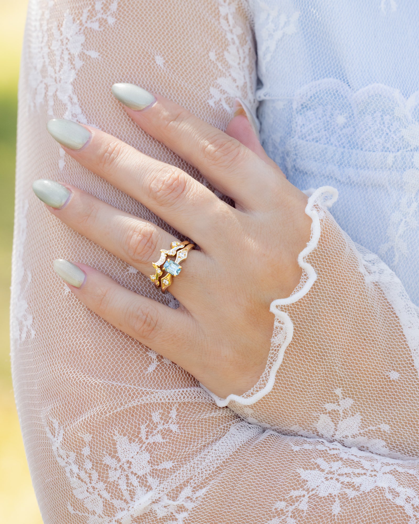 Close-up of a hand wearing a gold ring against a blurred background.