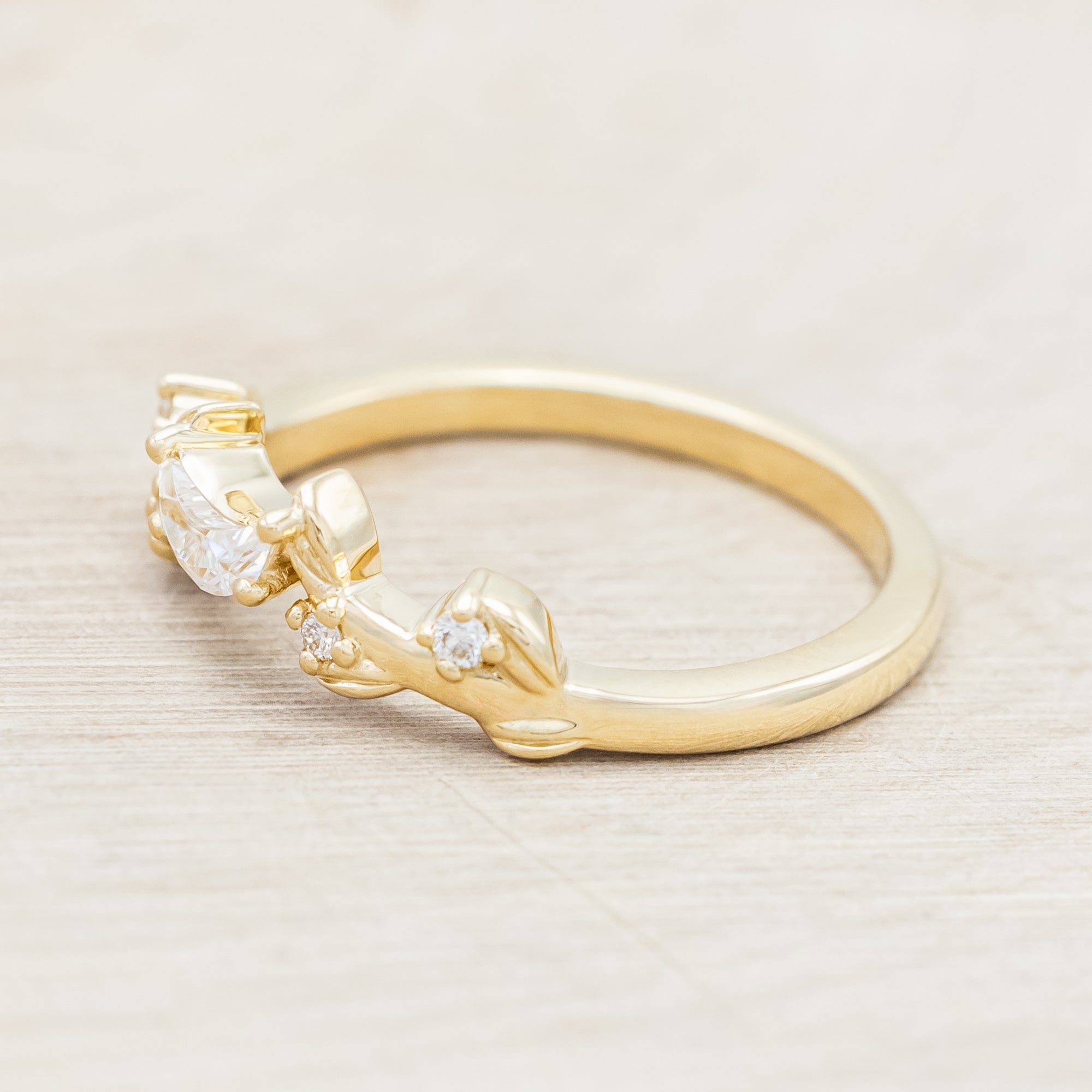 14K gold ring with diamond & moissanite accents on a beige background