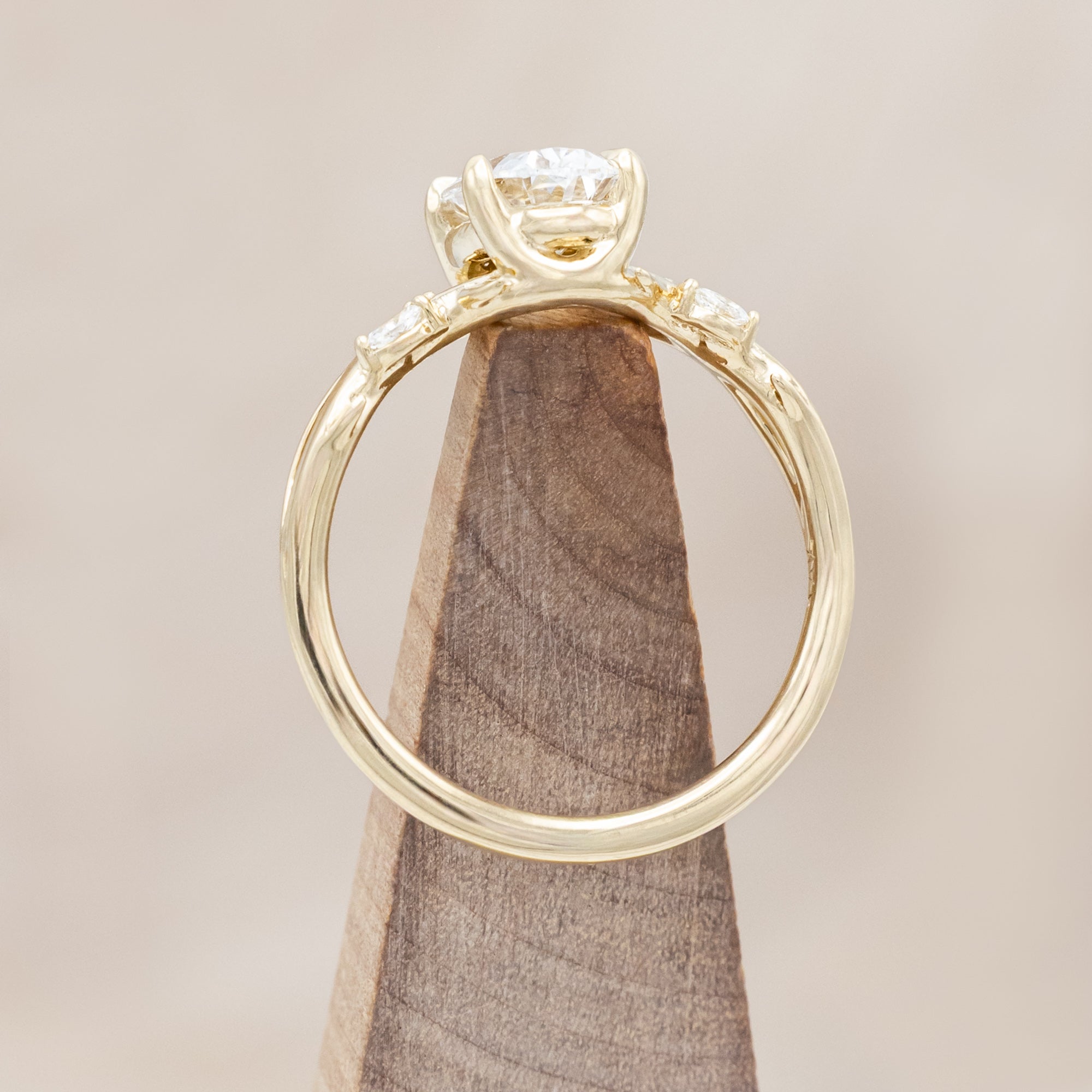 14K gold engagement ring with oval lab-grown diamond and accents against beige background