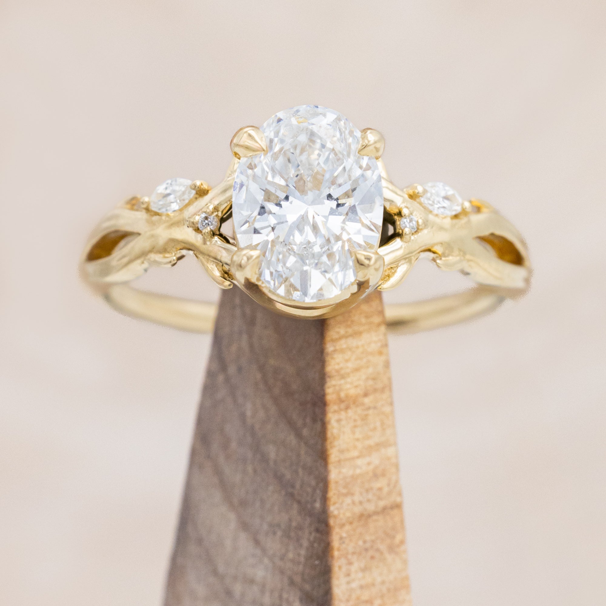 14K gold engagement ring with oval lab-grown diamond and accents against beige background