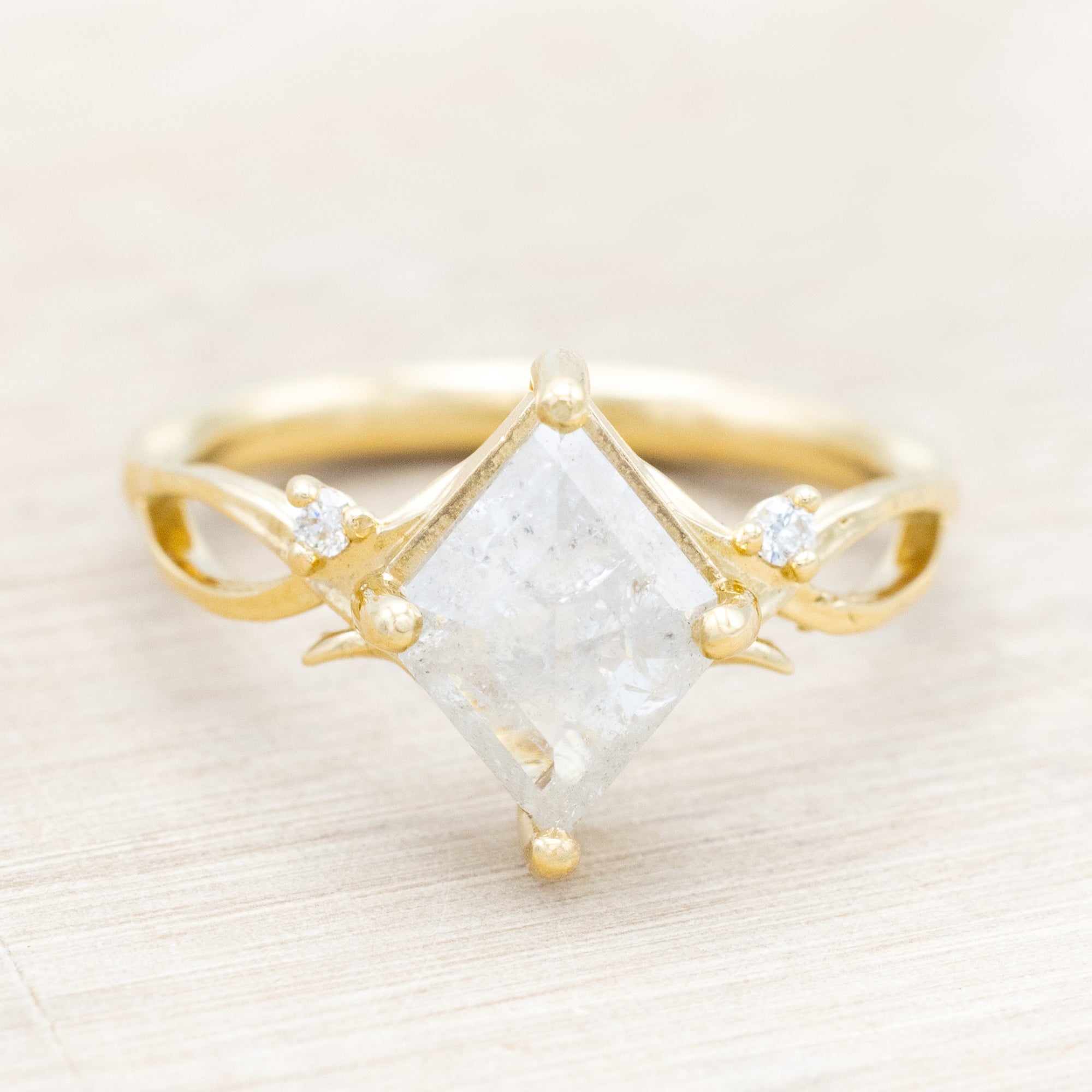 14K yellow gold ring with a salt & pepper diamond and diamond accents on a beige background