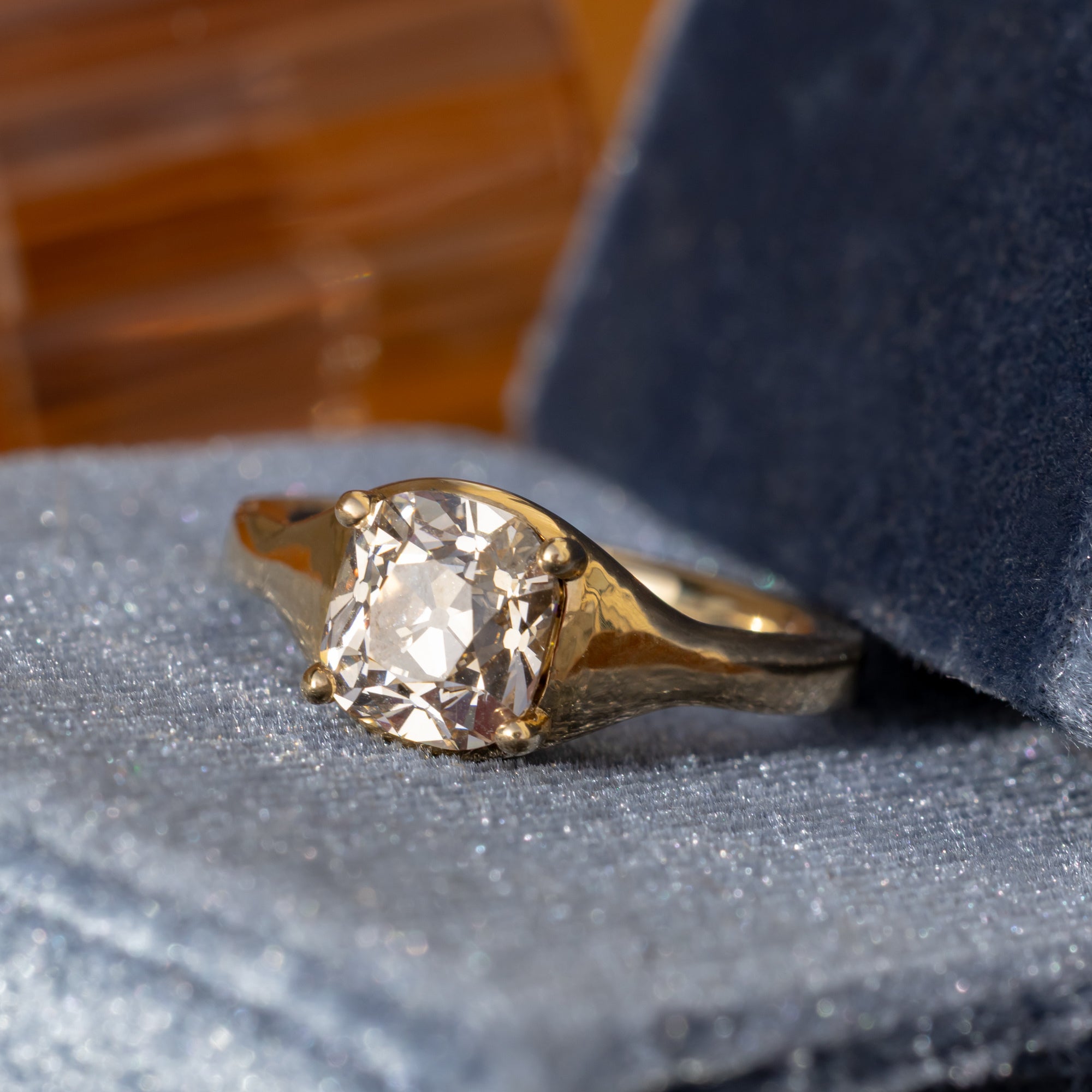 Gold ring with a large diamond on a textured surface