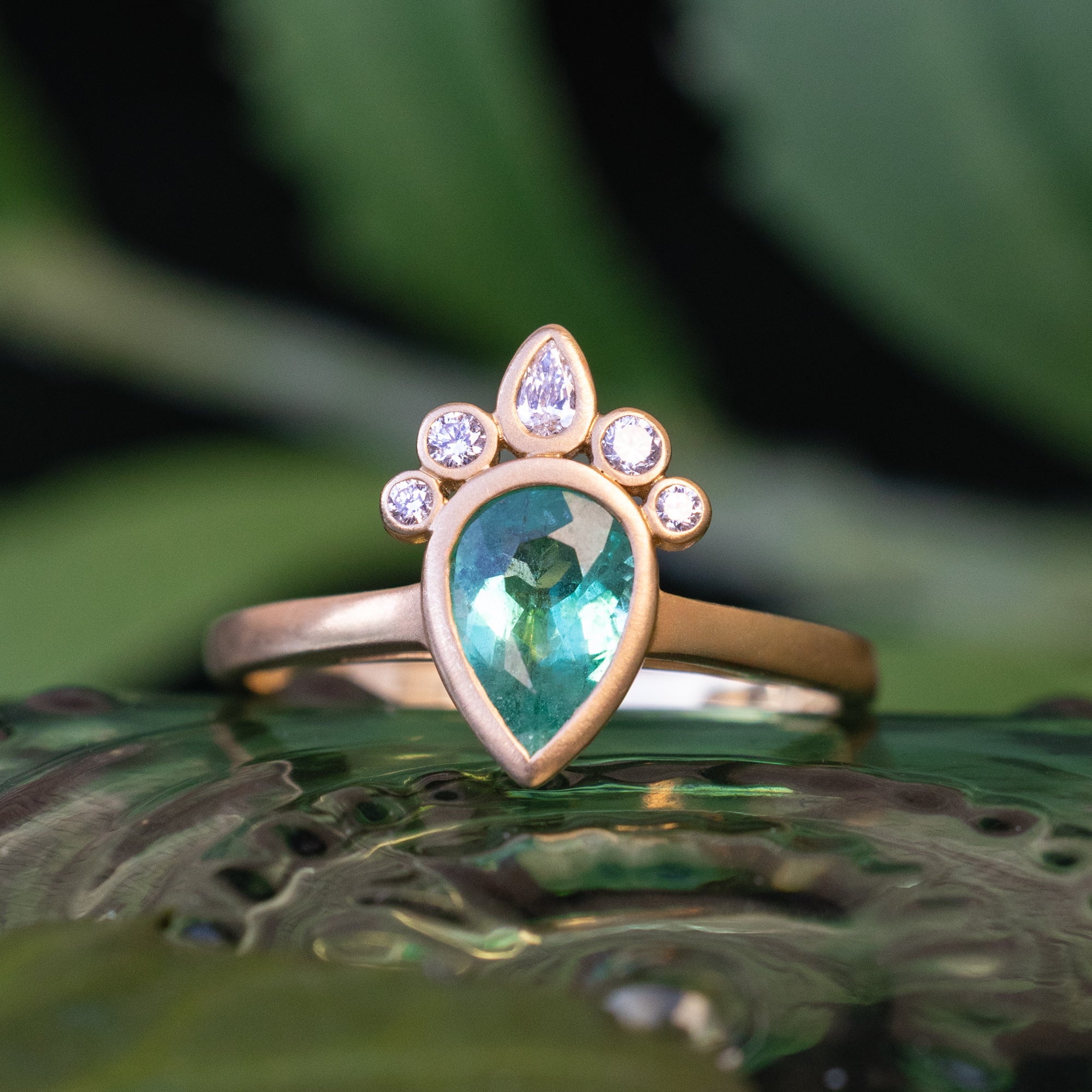 ONE-OF-A-KIND - "CIRCE" - BEZEL-SET ENGAGEMENT RING WITH PEAR CUT NATURAL EMERALD & DIAMOND ACCENTS ON A BRUSHED 18K GOLD BAND-Staghead Designs