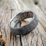 Shown here is a handcrafted men's wedding ring featuring a hammered finish and antler lining on any of our available base material options, tilted right. Additional inlay options are available upon request.