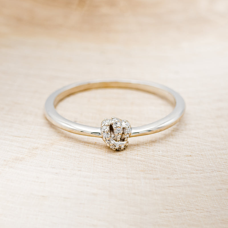 Shown here is a dainty-style knot women's stacking band with diamond accents, front facing.