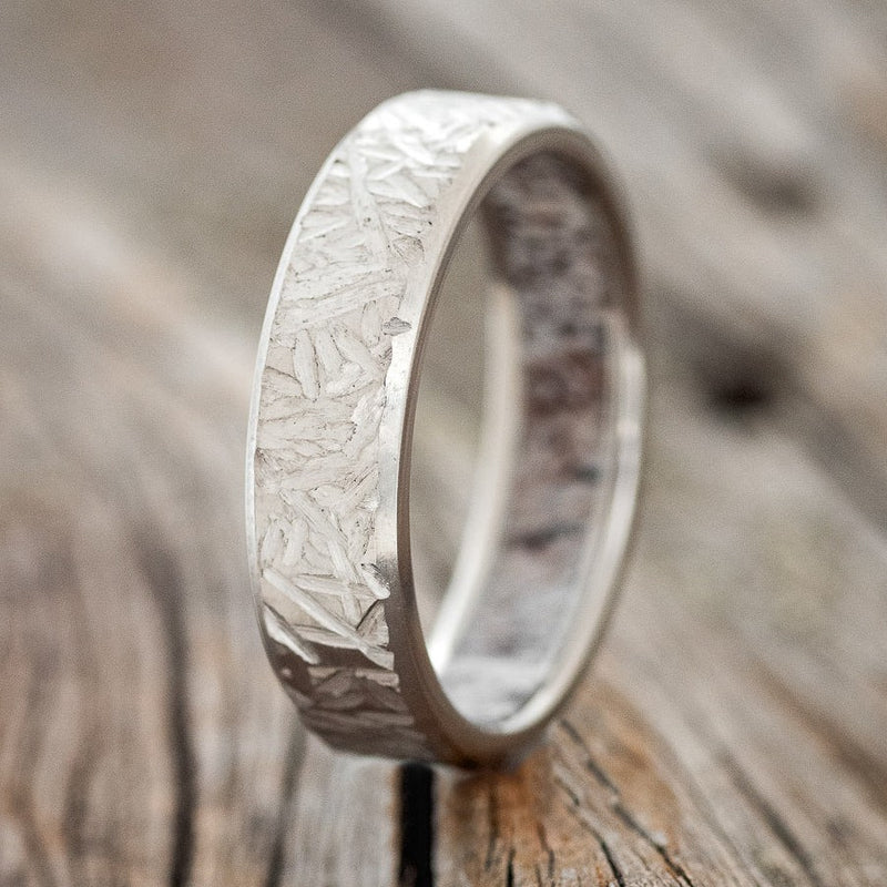 Shown here is a handcrafted men's wedding ring featuring a unique antler lining with a crosshatched finish, upright facing left. Additional inlay options are available upon request.