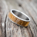 Shown here is "Rainier", a custom, handcrafted men's wedding ring featuring spalted maple wood inlay, tilted left. Additional inlay options are available upon request.