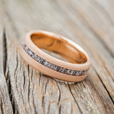 Shown here is "Vertigo", a custom, handcrafted men's wedding ring featuring an offset antler inlay on a sandblasted 14K gold band, tilted left. Additional inlay options are available upon request.