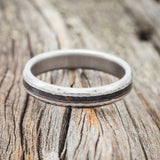 Shown here is "Perenna", a custom, handcrafted women's stacking band featuring a patina copper inlay, shown here on a titanium band with a hammered finish, laying flat. Additional inlay options are available upon request.