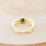 Shown here is "Anastasia", a split shank-style turquoise women's engagement ring with diamond accents, back view.