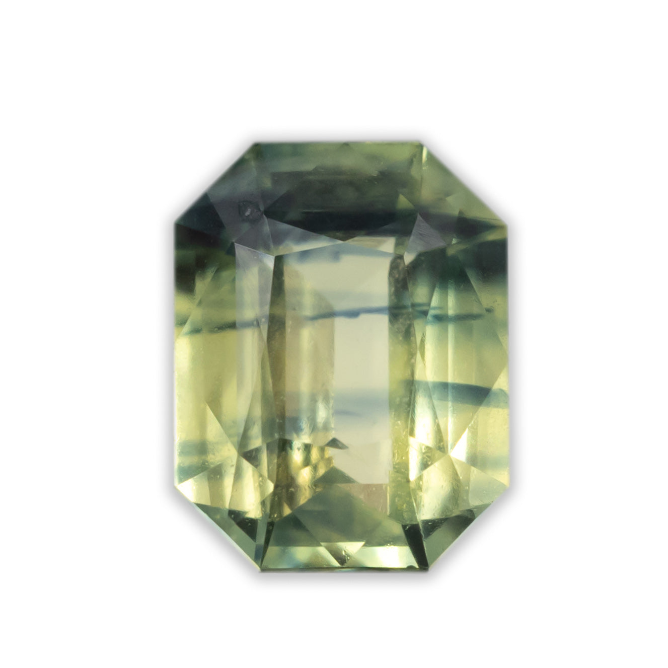 Octagon cut yellow-green sapphire with dark green veins on a white background