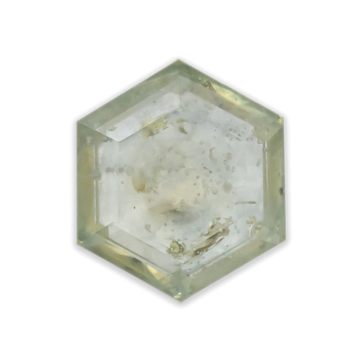 A pale green sapphire in a hexagon cut against a white background