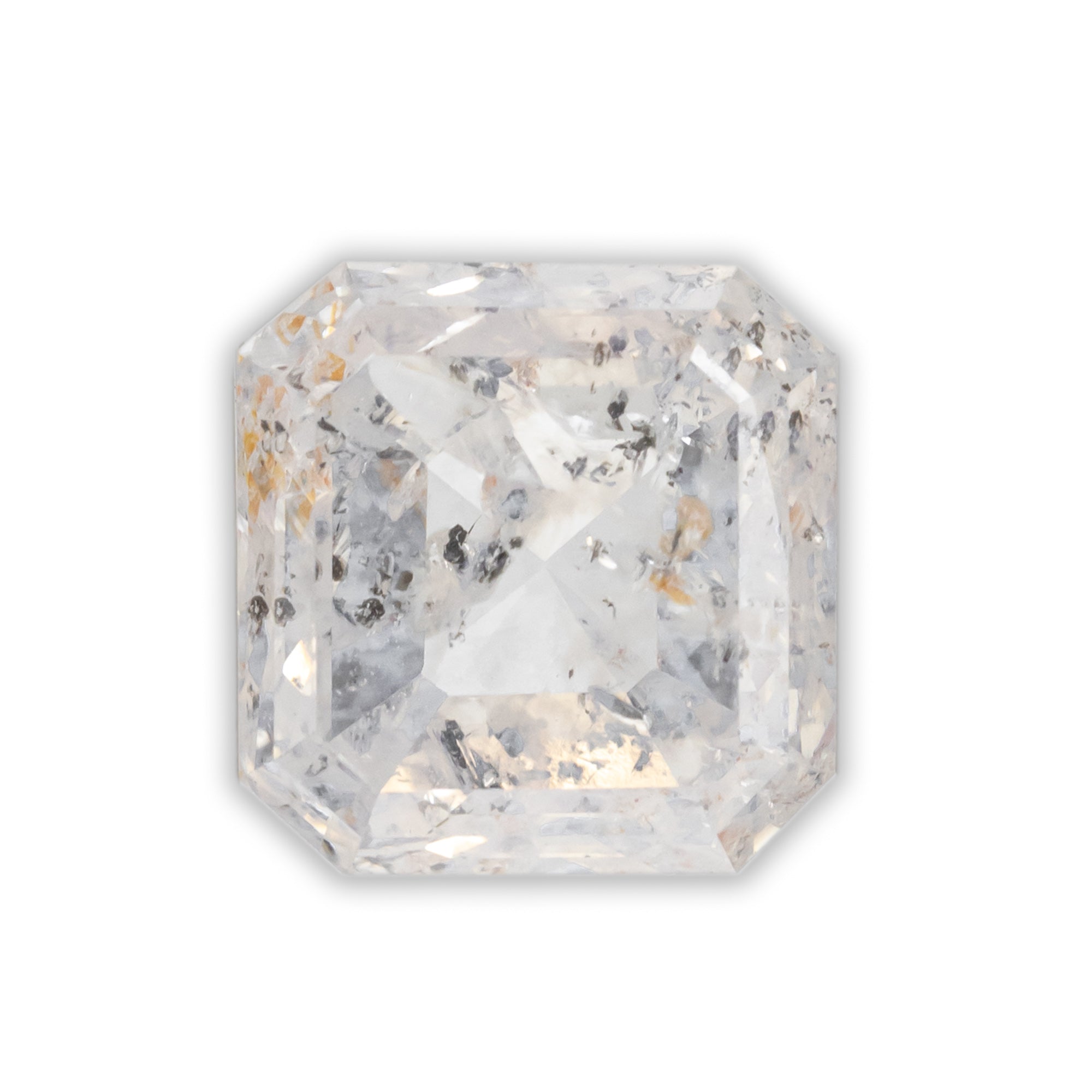 An Asscher cut salt & pepper diamond with gold and black inclusions on a white background.